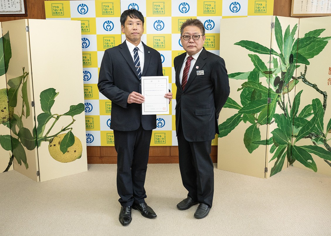 固定資産評価審査委員会委員に再任された林さんと記念撮影をする西平市長の写真