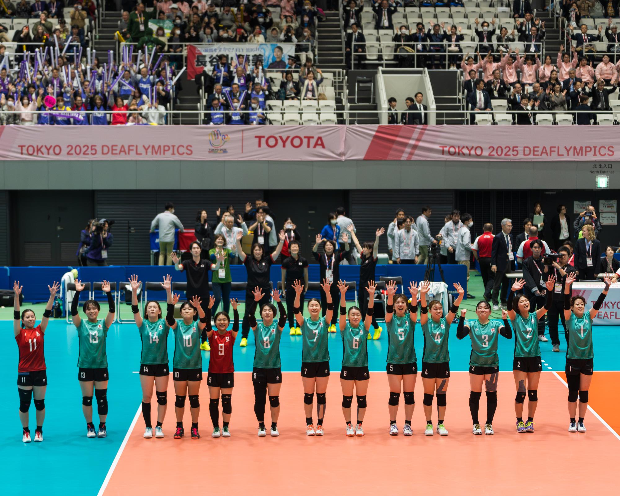 試合終了後、コートの真ん中に整列し、手話で拍手をする選手らの写真