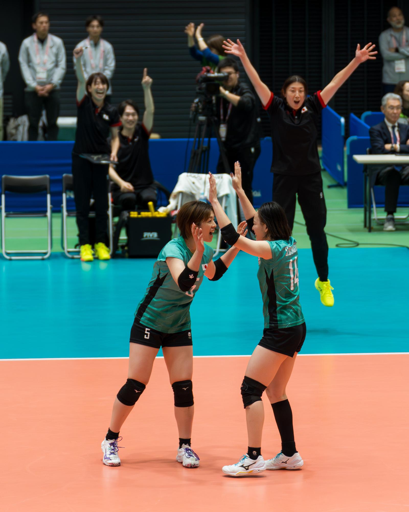 仲間が得点して喜び合う尾塚選手の写真