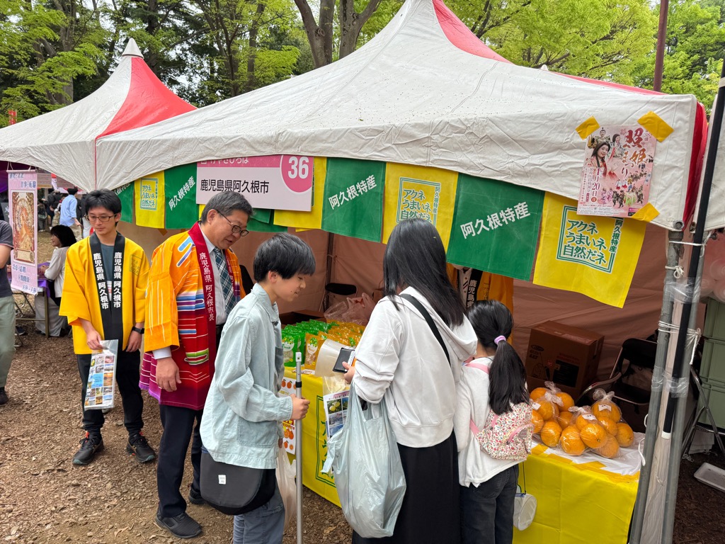 照姫まつりの物販ブースで阿久根をPRする西平市長とブースを訪れた来場者の写真