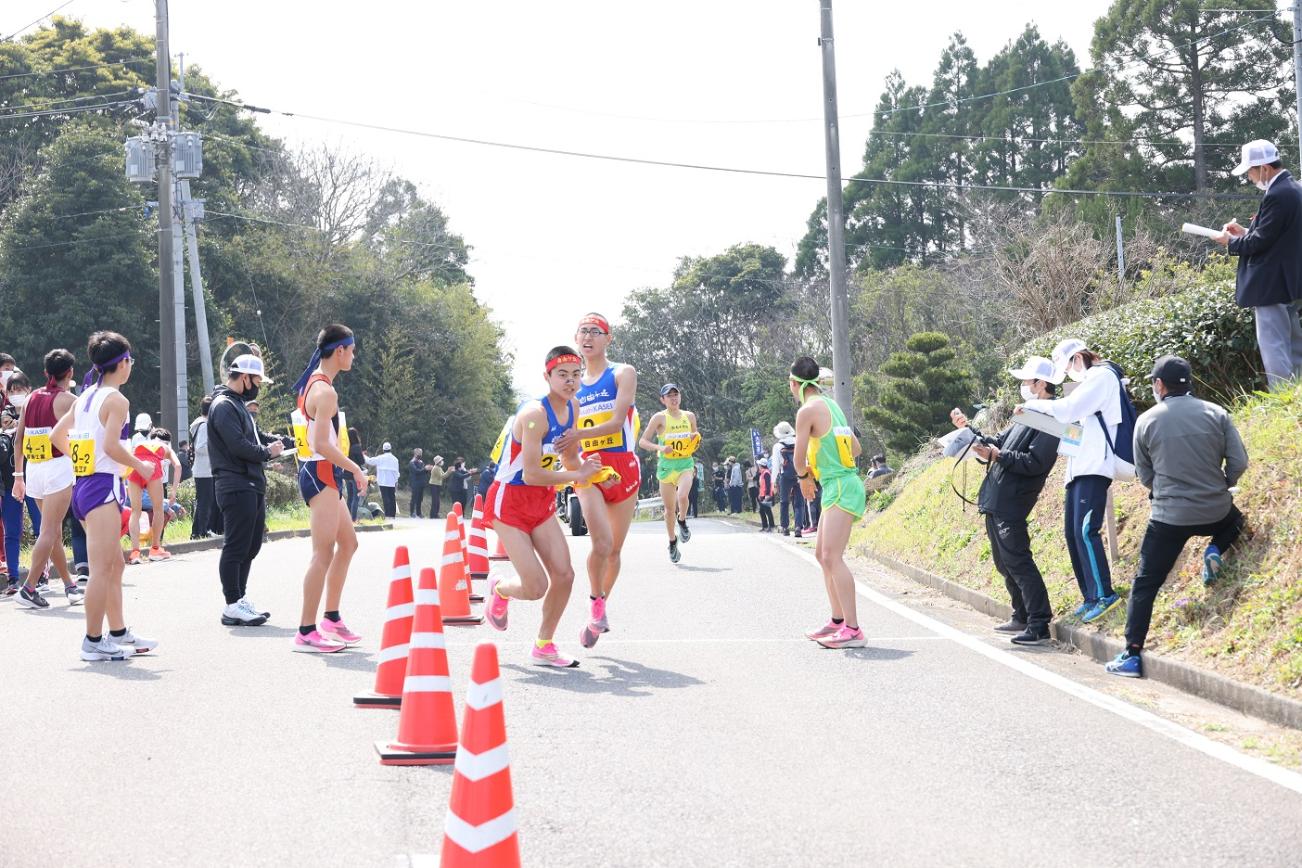 中継所で襷を繋ぐ男子選手たちの写真