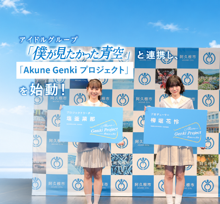 「僕が見たかった青空」の塩釜さんと柳堀さんが特大名刺を持って記念撮影する写真