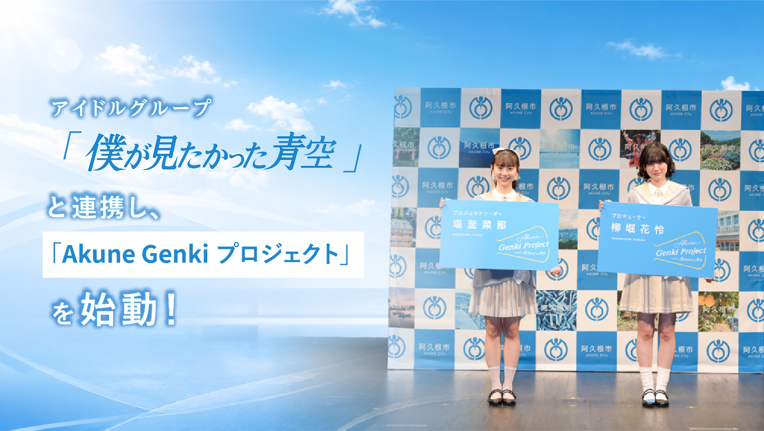 「僕が見たかった青空」の塩釜さんと柳堀さんが特大名刺を持って記念撮影する写真