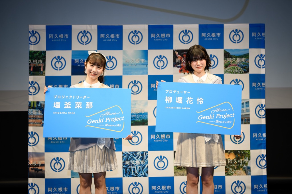 特大名刺を持って記念撮影をするプロジェクトリーダーの塩釜 菜那さん（写真左）とプロジェクトプロデューサーの柳堀 花怜さん（写真右）
