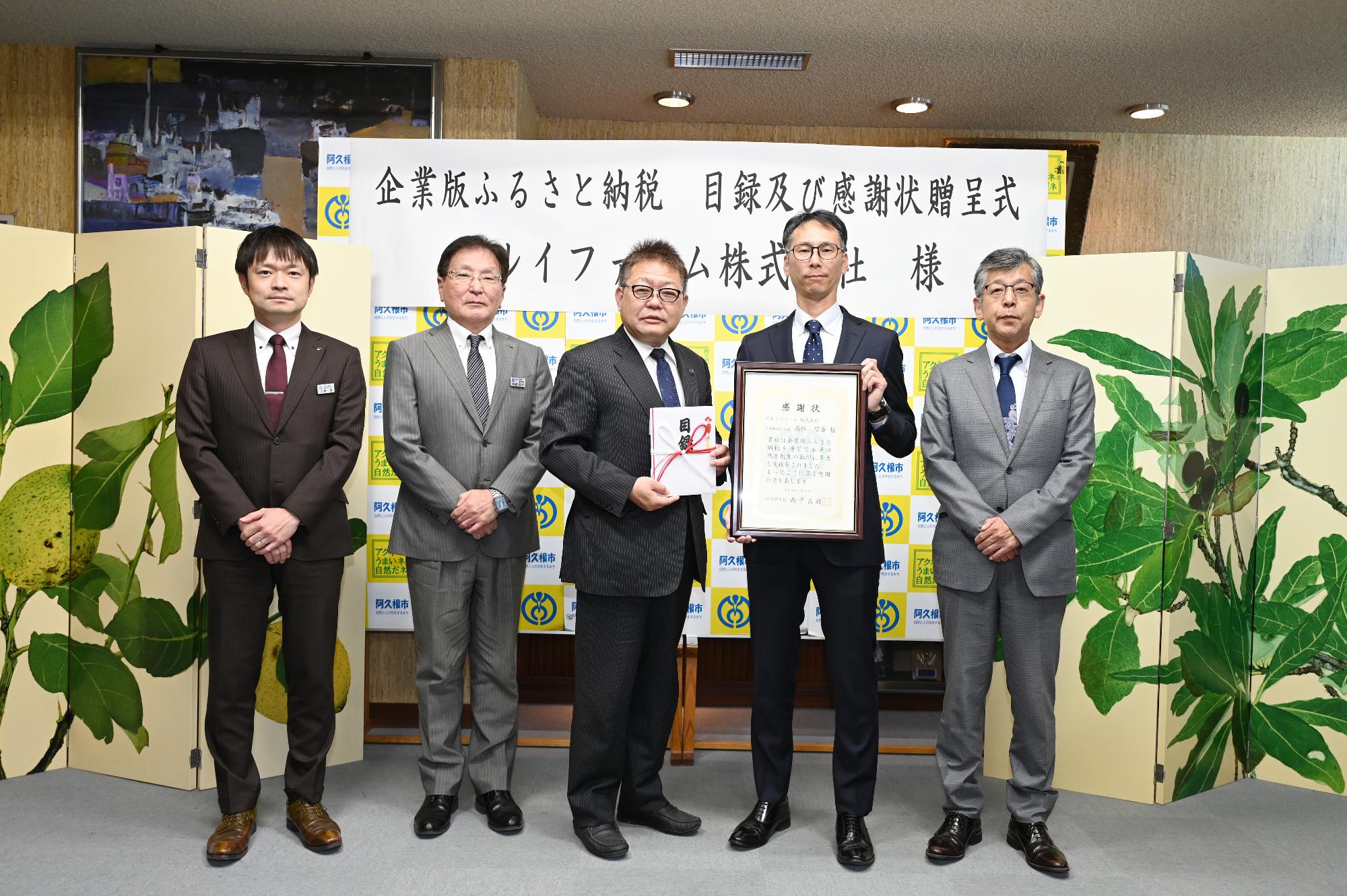 企業版ふるさと納税の目録および感謝状贈呈式の集合写真（左から上野副市長、松崎副市長、阿久根市長、マルイ関係者2人）