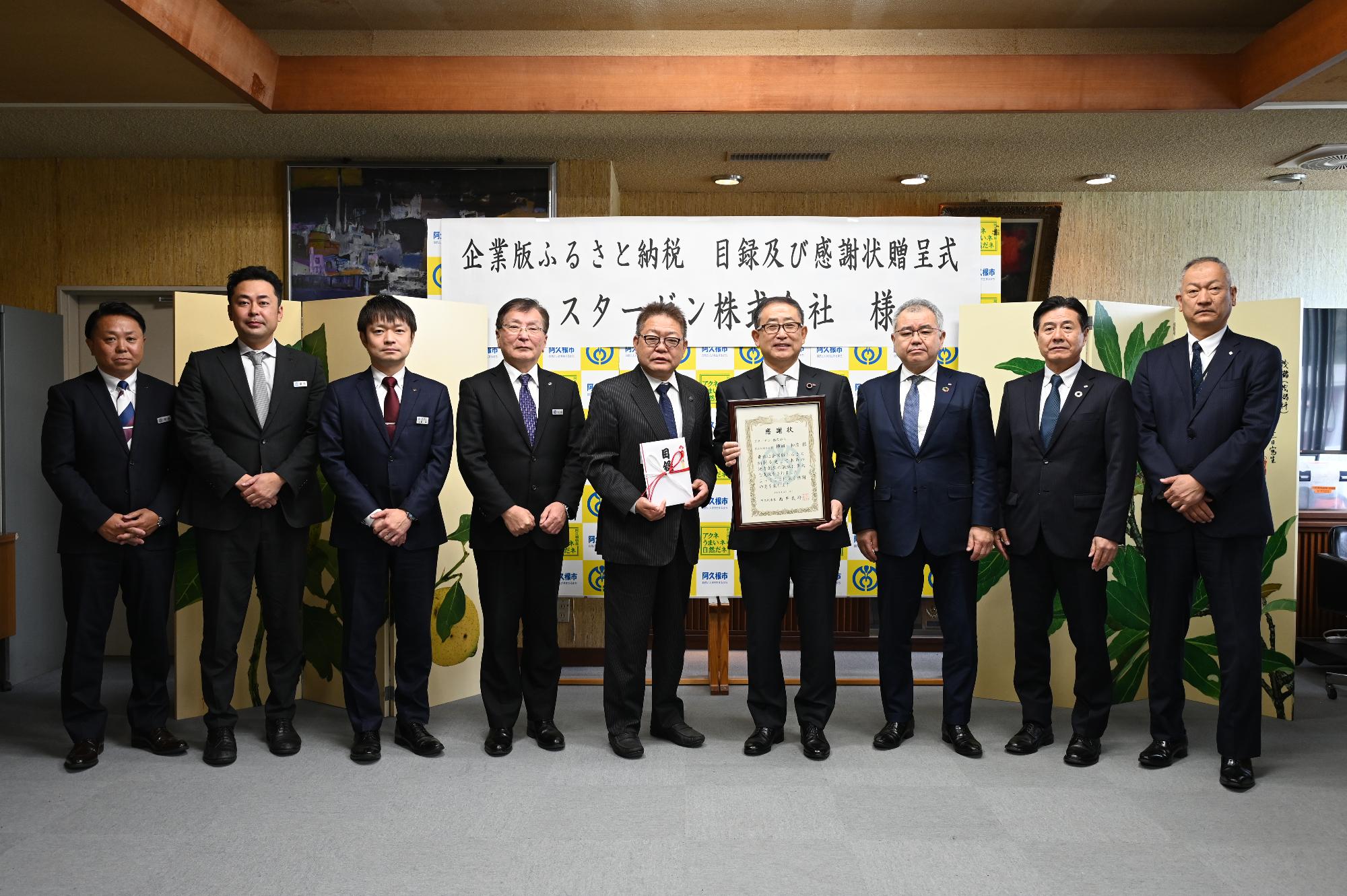 企業版ふるさと納税の目録および感謝状贈呈式の集合写真（左から早水生涯学習課長、冨永企画推進課長、上野副市長、松崎副市長、阿久根市長、スターゼン関係者4人）