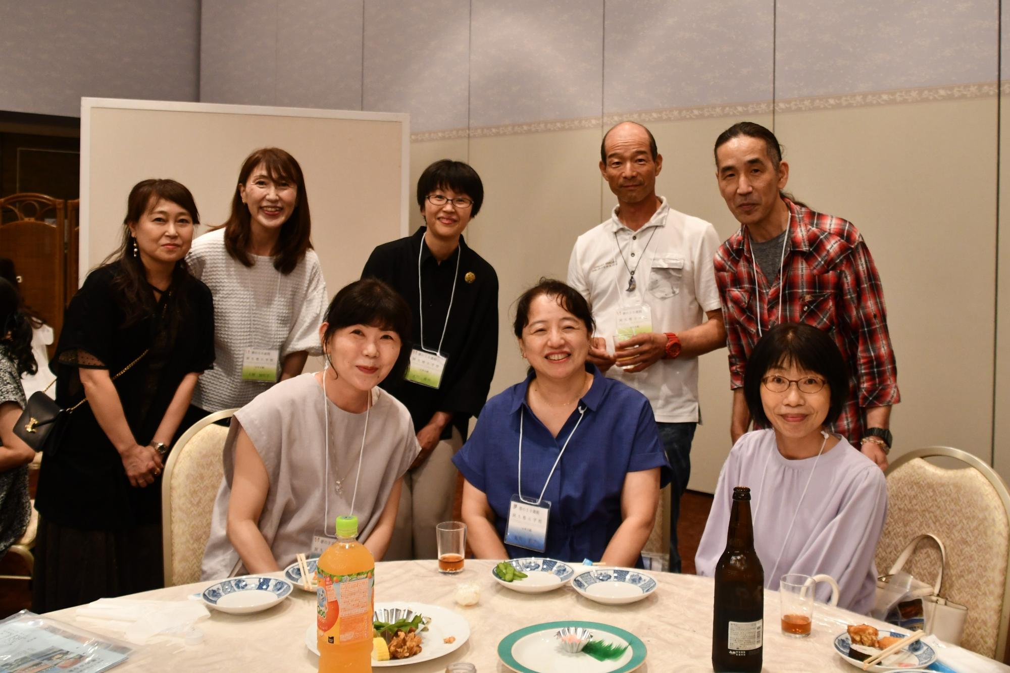 阿久根小出身の参加者たちの写真（テーブルを囲む8人の男女）