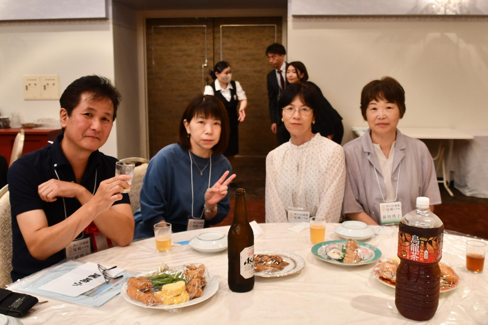 尾崎小出身の参加者たちの写真（テーブルを囲む4人の男女）
