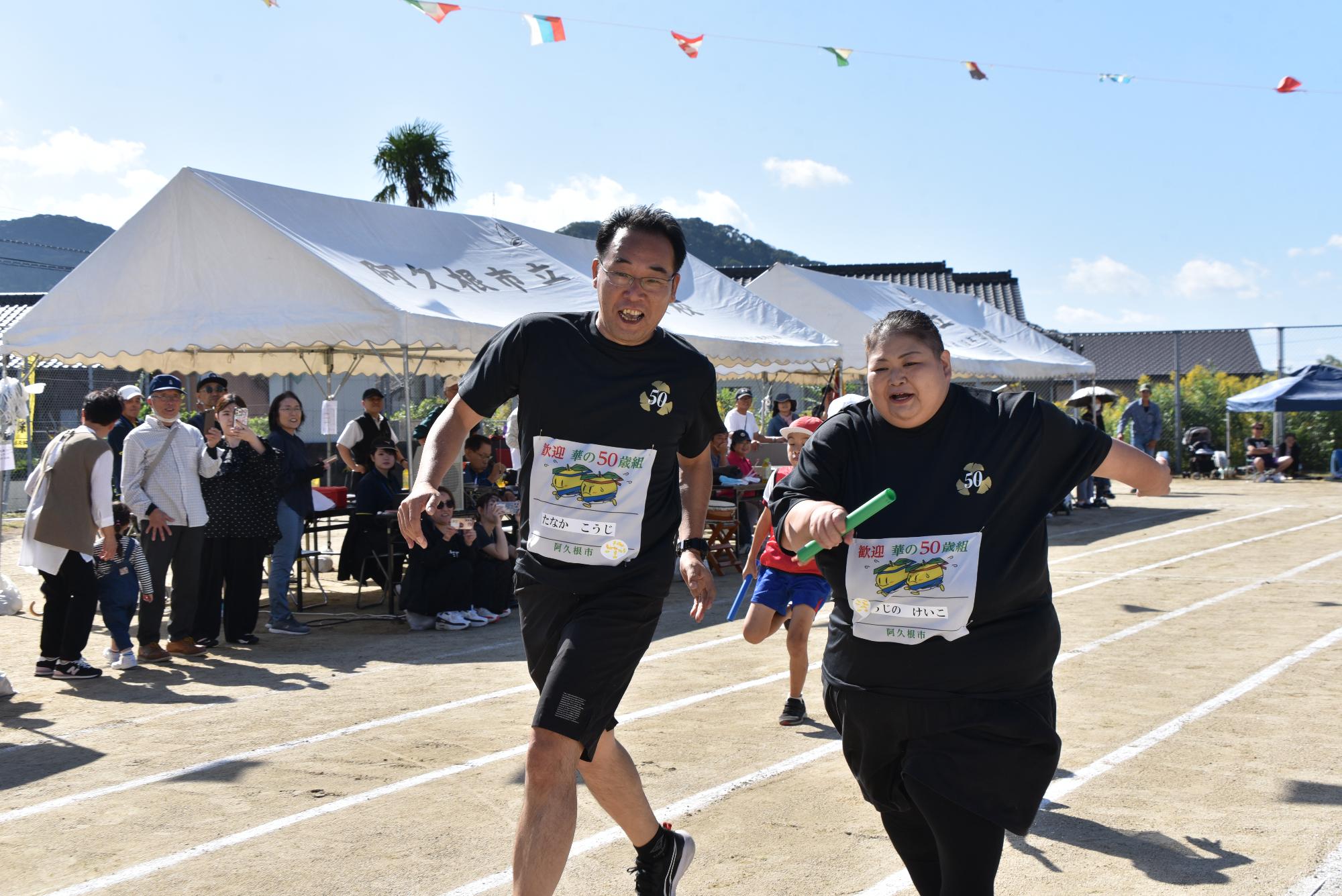 リレーで競い合う男女2人の参加者の写真