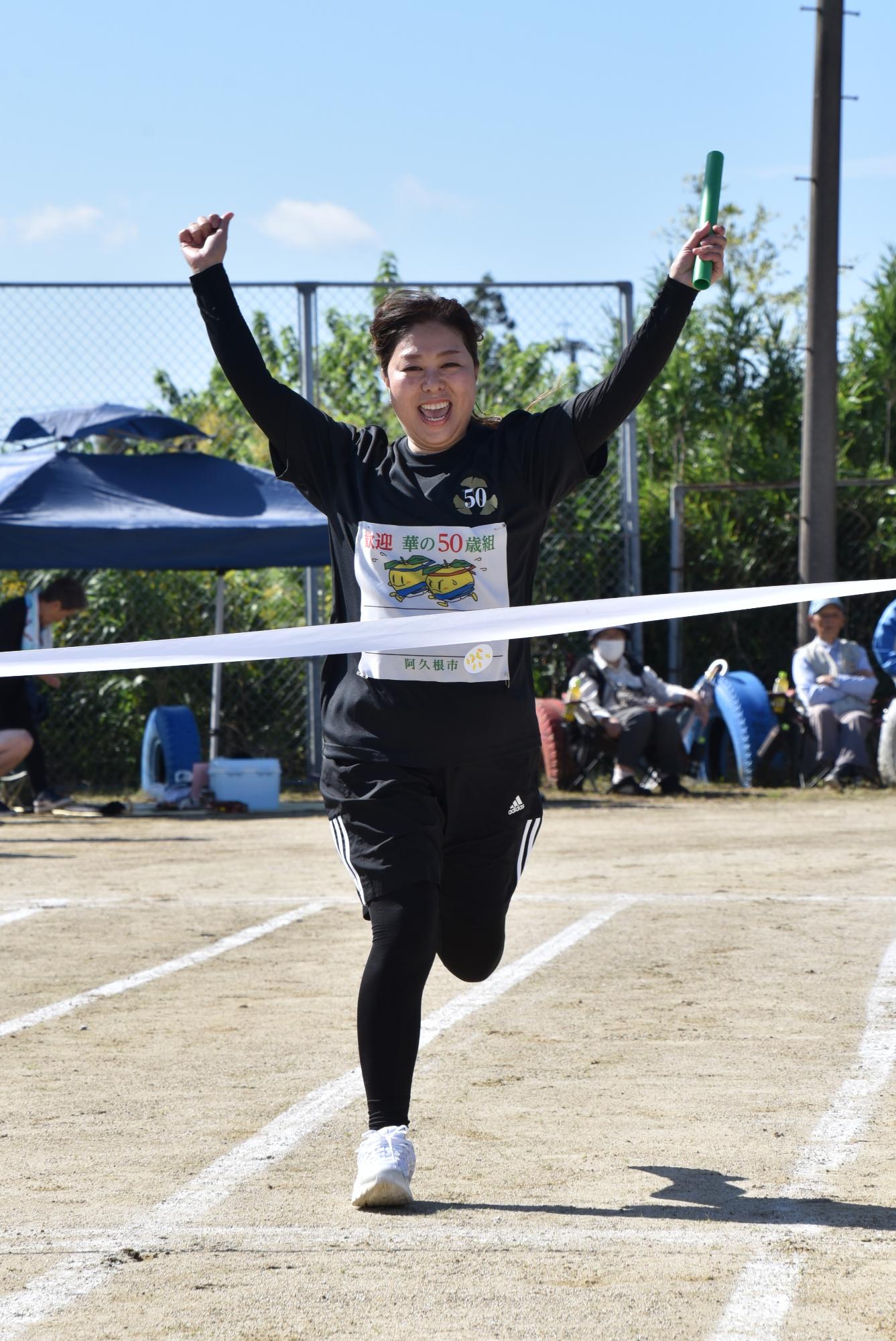 笑顔で両手をあげながらゴールをする参加者の写真