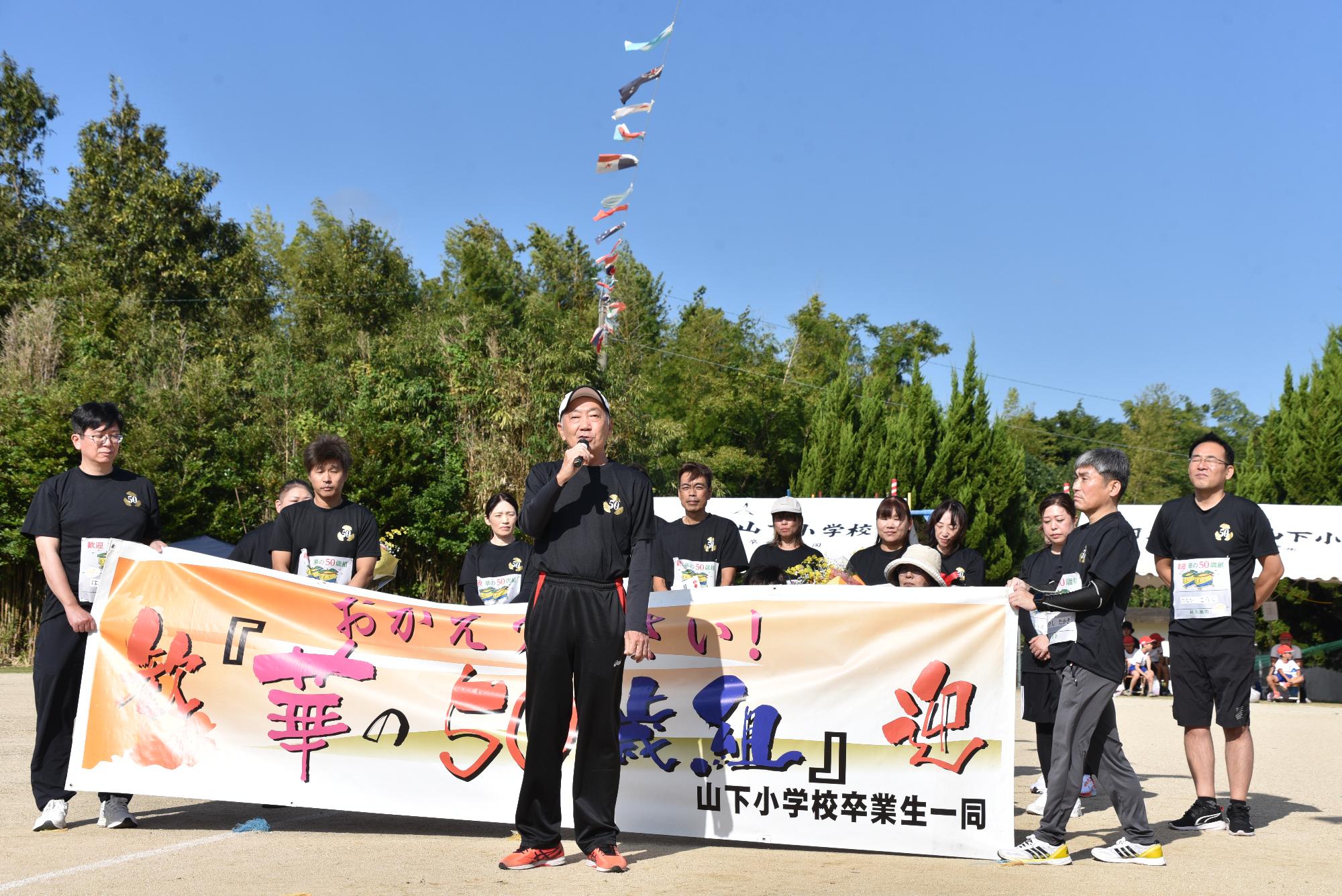 華の50歳組であいさつをする当時の先生の写真