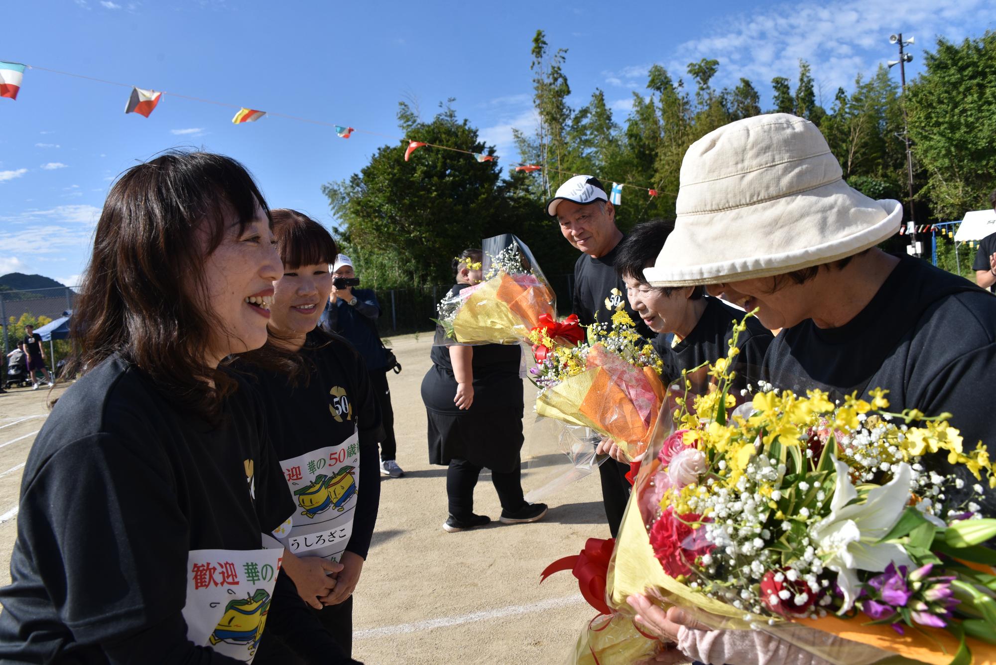 当時の先生方に花束を贈呈する華の50歳組の参加者の写真