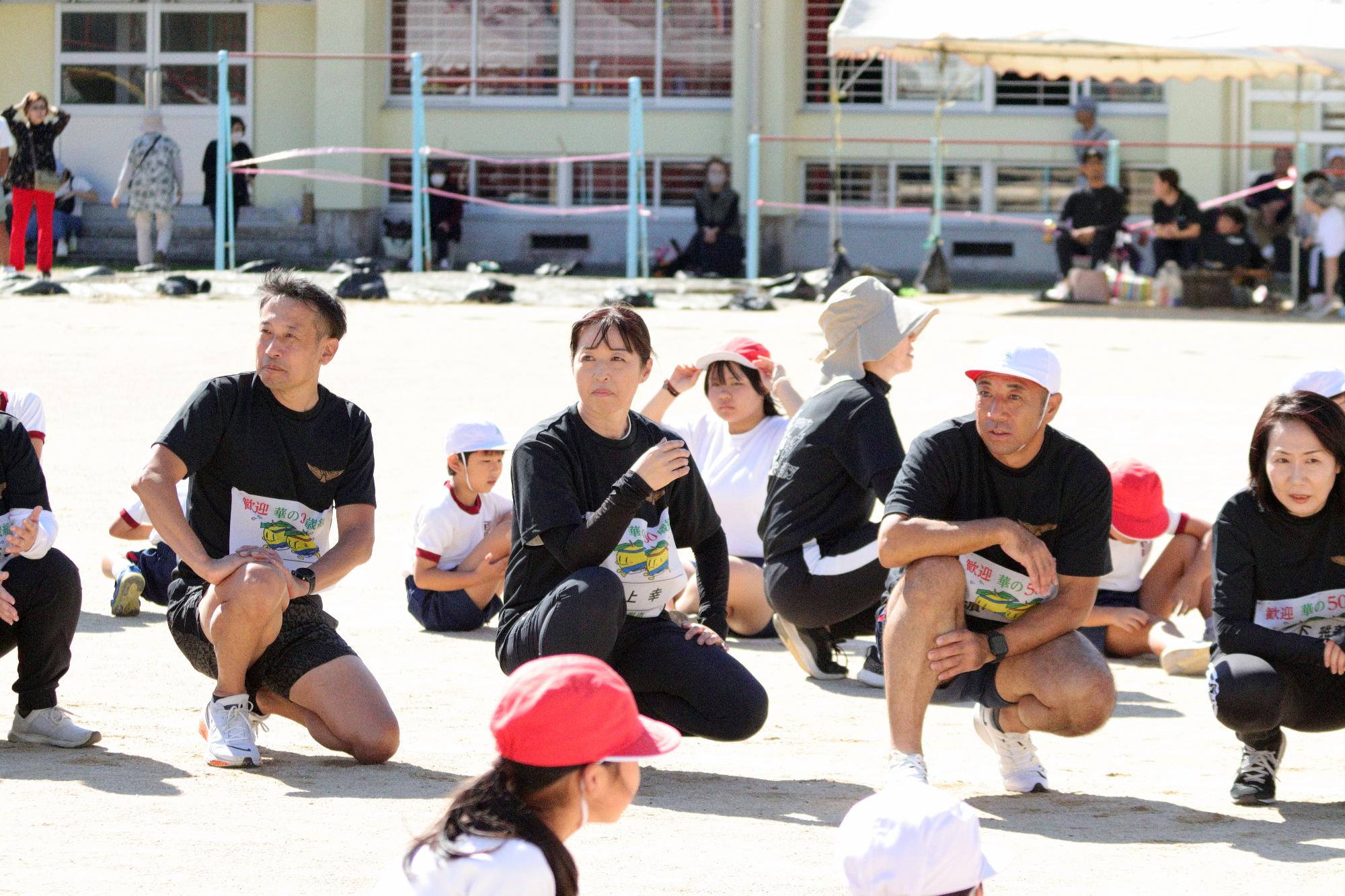 リレーで座って待機してリレーを見守る参加者の写真（その2）