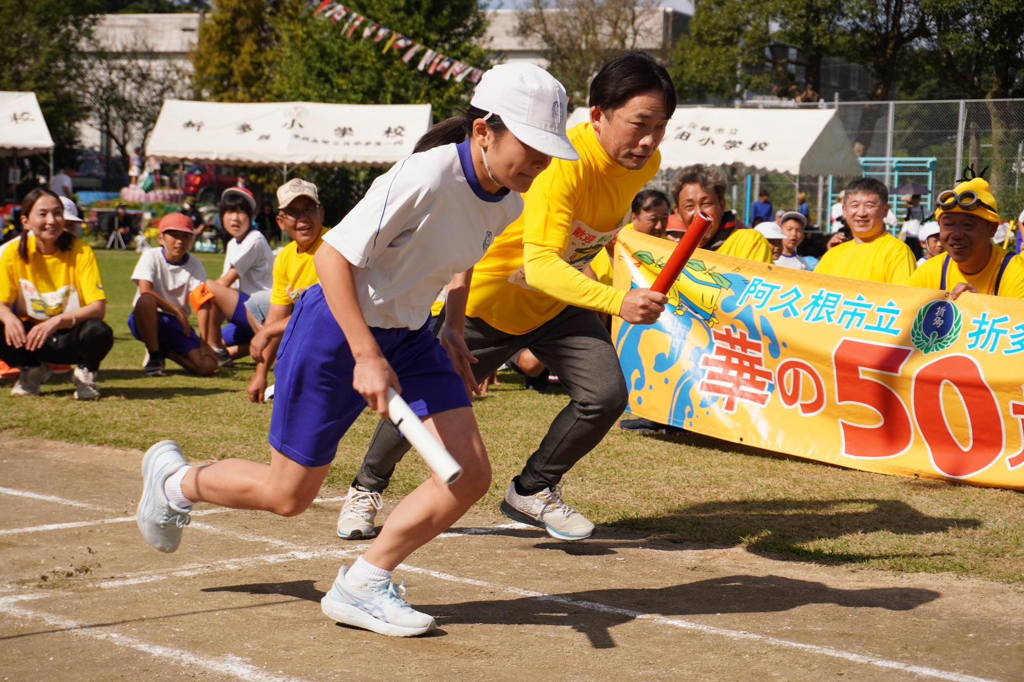 リレーで競い合う小学生と参加者の写真（その1）