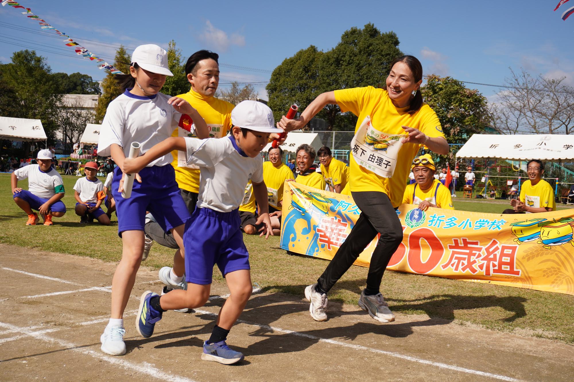 リレーで競い合う小学生と参加者の写真（その2）