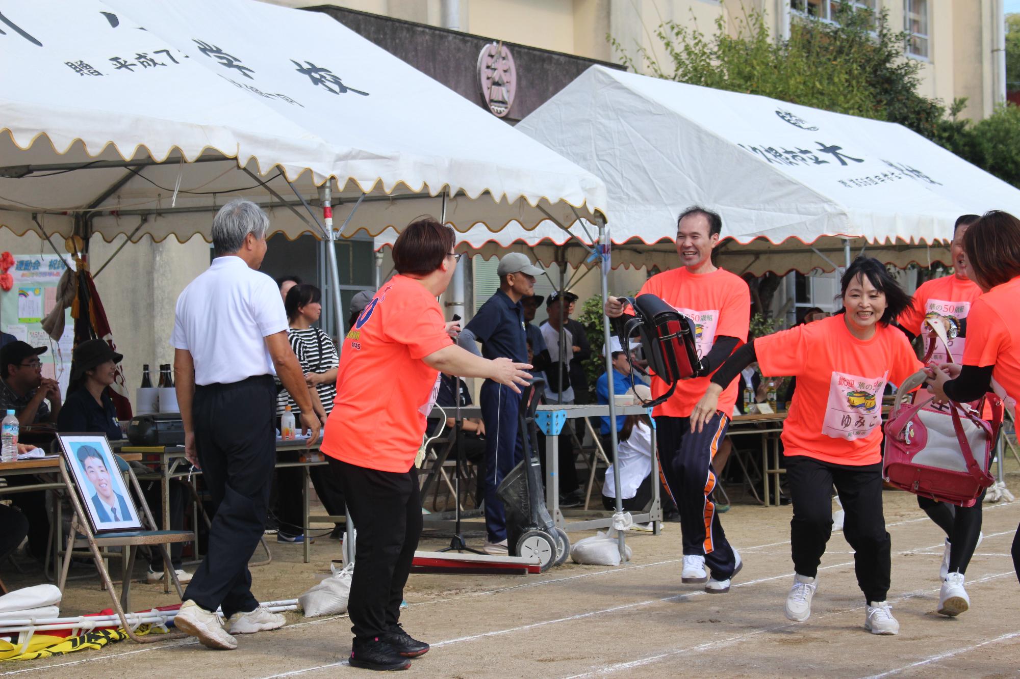 ランドセルをバトンとしてつなぐ参加者の写真（その1）