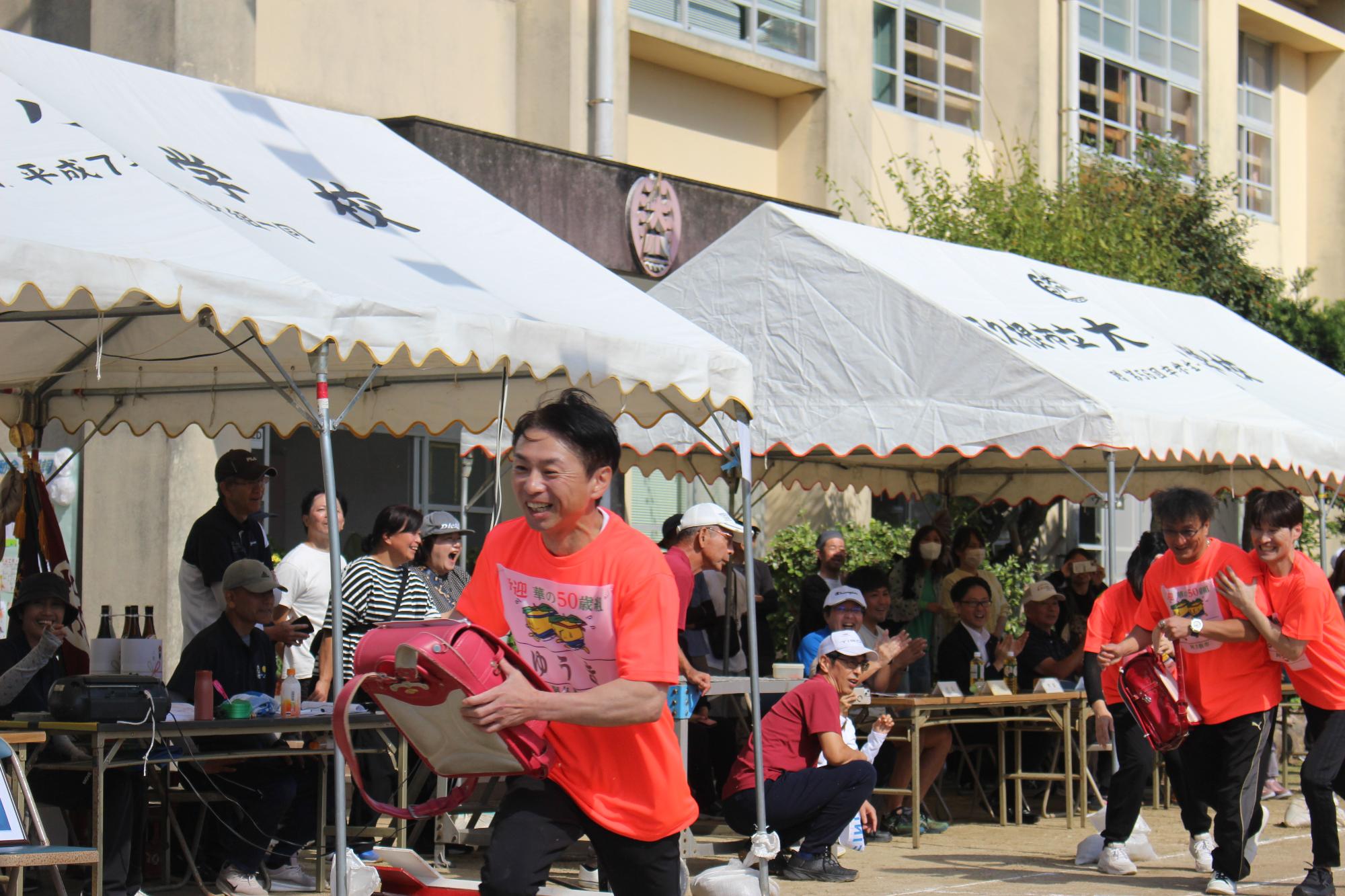 ランドセルをバトンとしてつなぐ参加者の写真（その2）