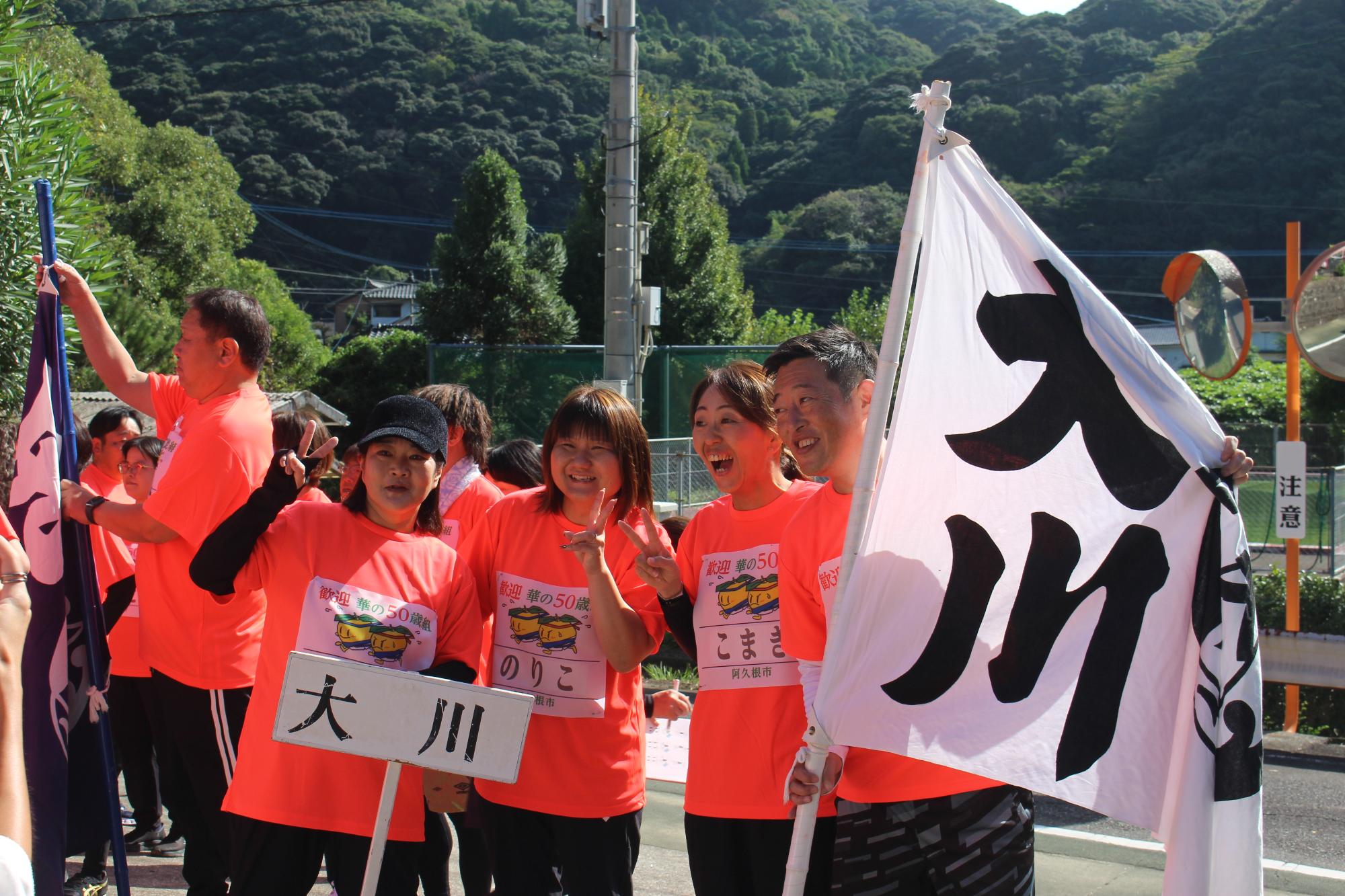 「大川」と書かれた旗を持ちながら記念撮影を撮る参加者の写真