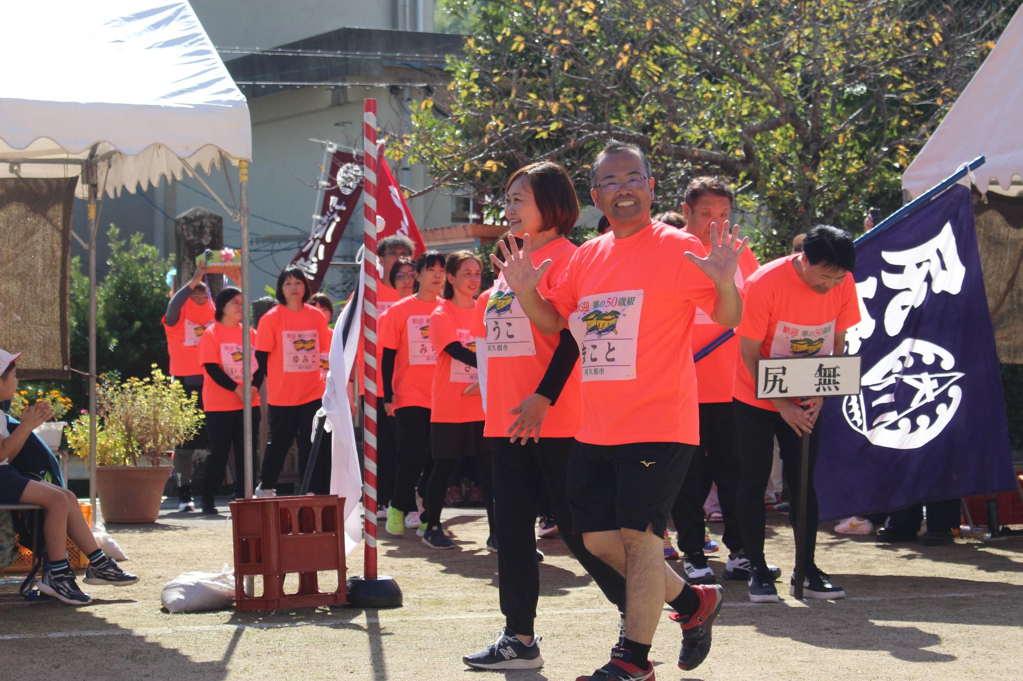 笑顔で手を振りながら入場する参加者の写真