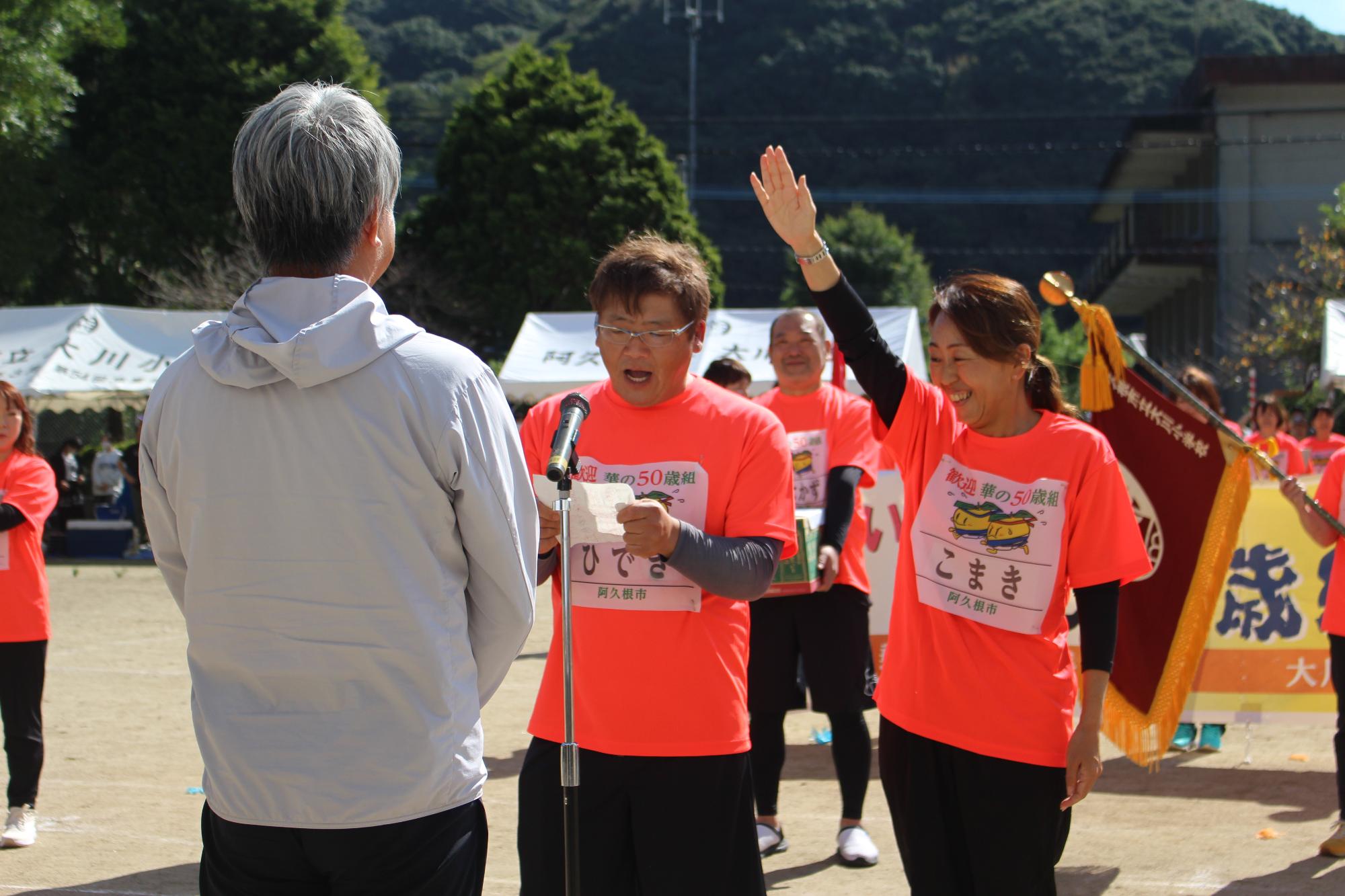 選手宣誓をする男女の写真