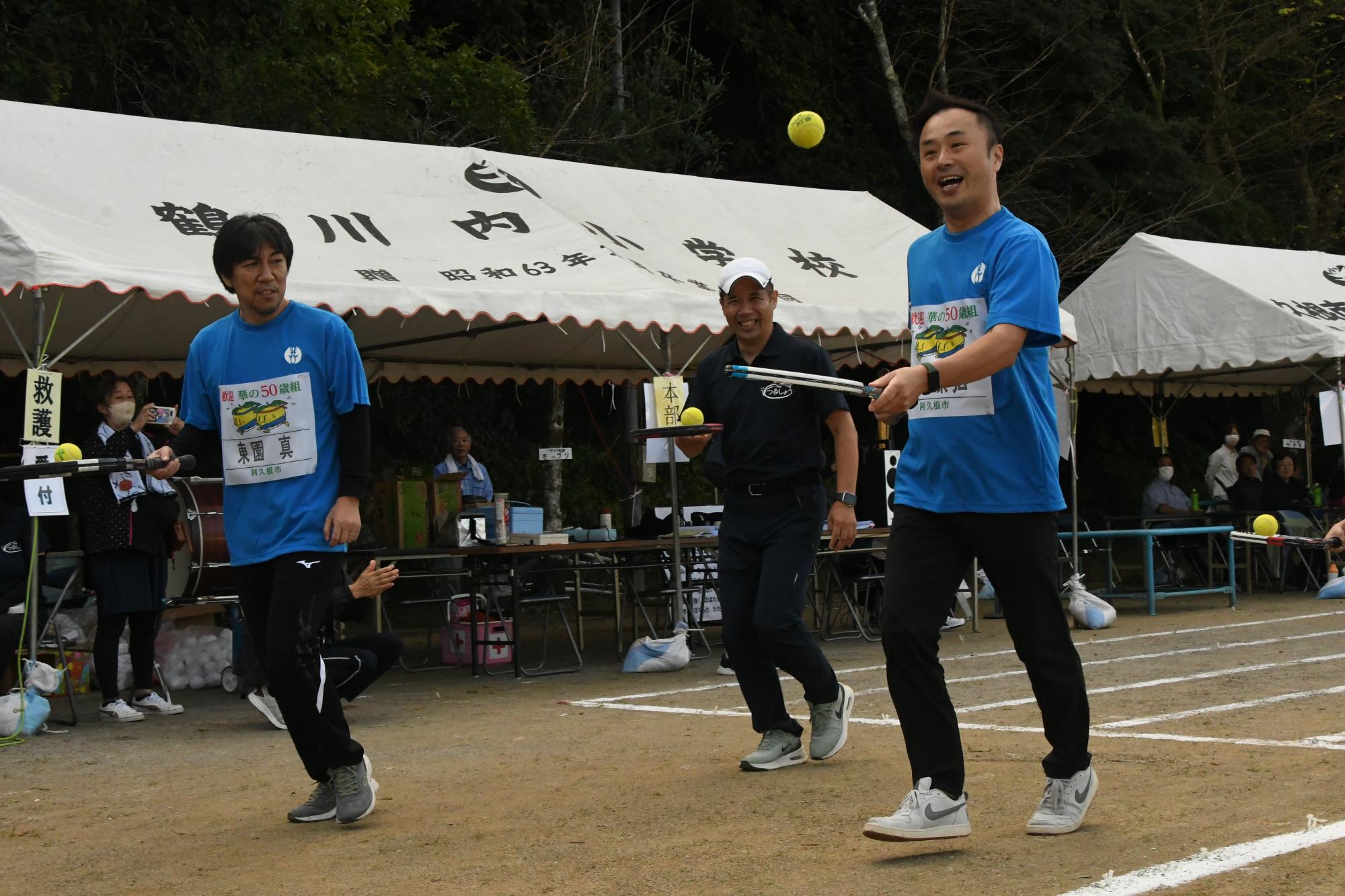 リレーでテニスラケットの面にテニスボールを乗せながら走る参加者の写真（その1）