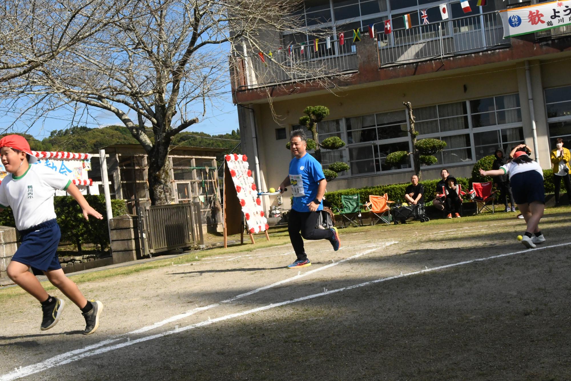 リレーでテニスラケットの面にテニスボールを乗せながら走る参加者の写真（その2）