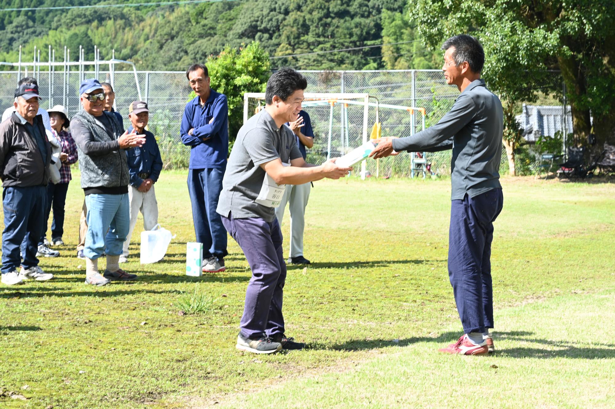 閉会式で地域の方から参加賞をもらう参加者の写真（その1）