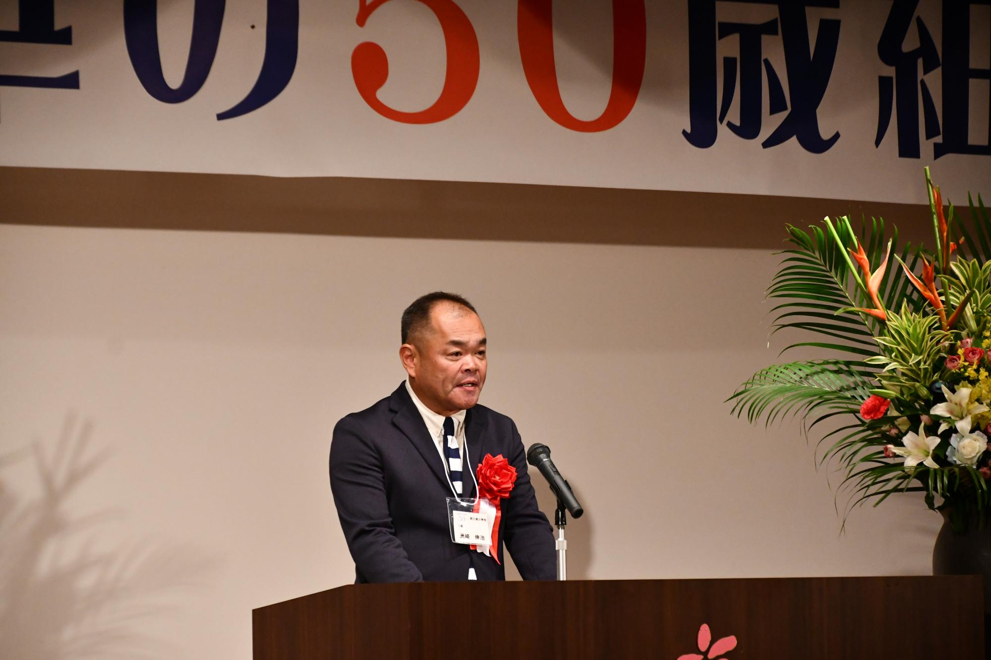 華の50歳組レセプションであいさつをする代表者の写真
