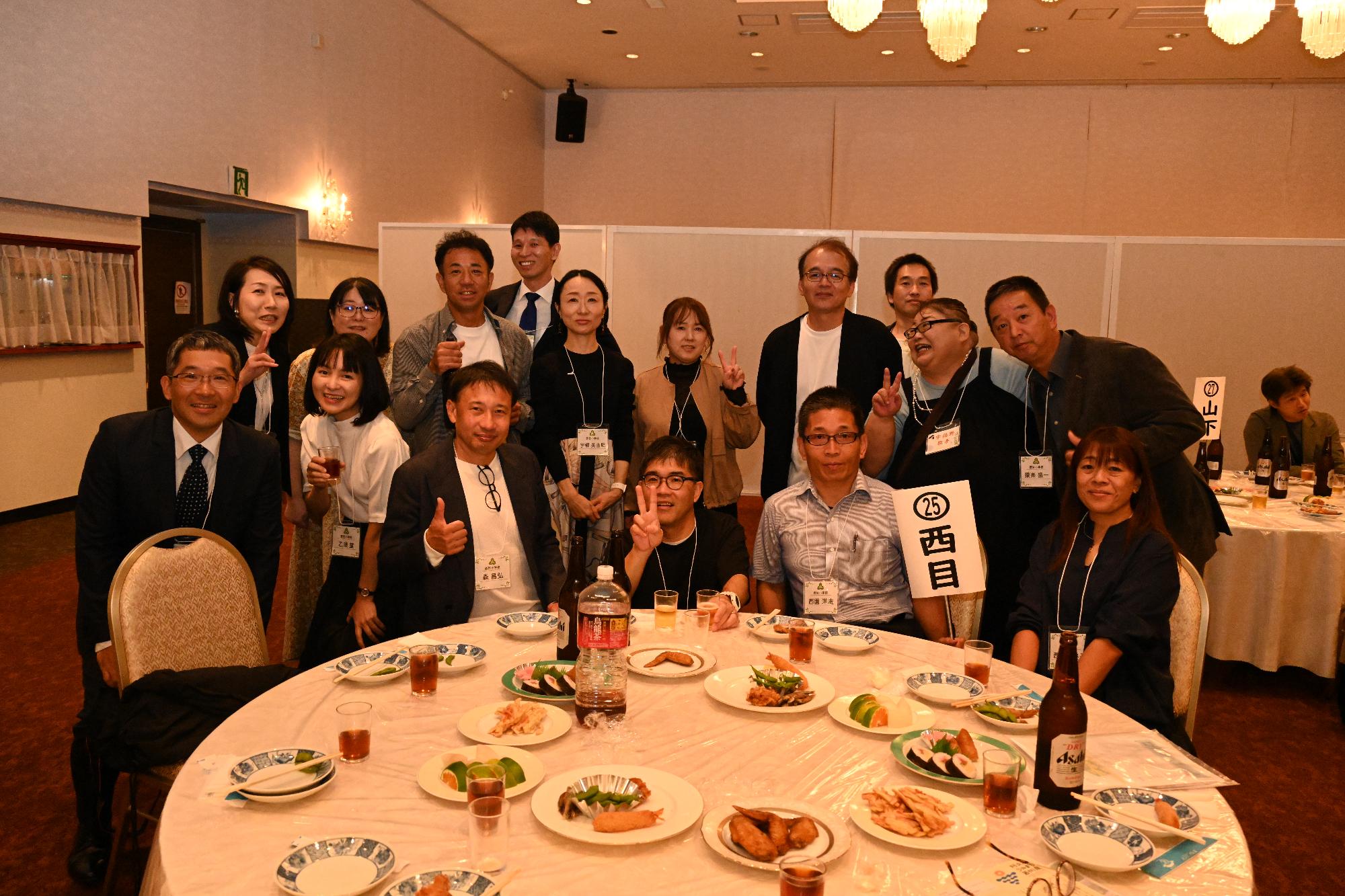 テーブルを囲む西目小出身の男女16人の写真