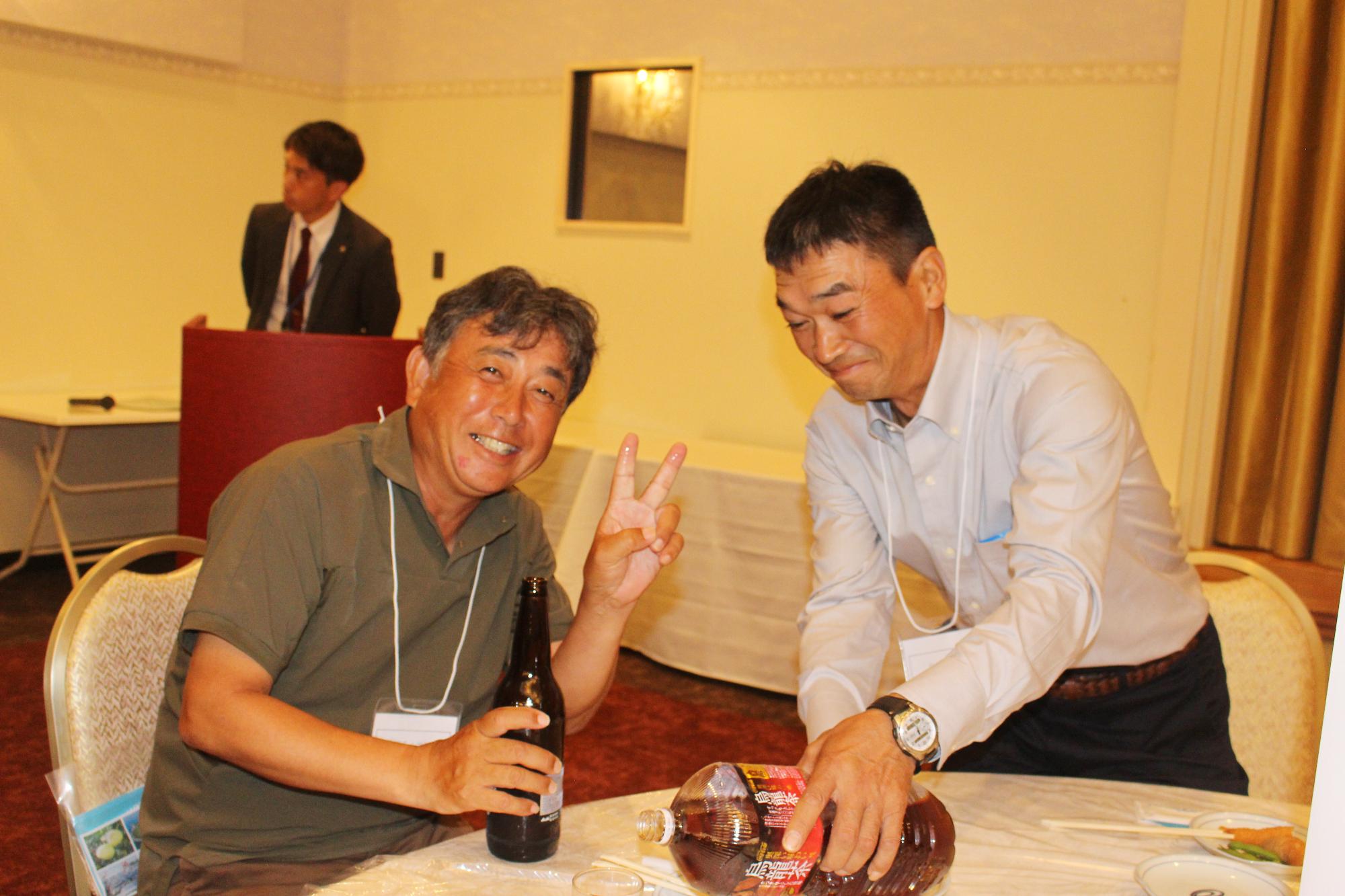 折多小出身の参加者たちの写真（テーブルを囲む2人の男性）