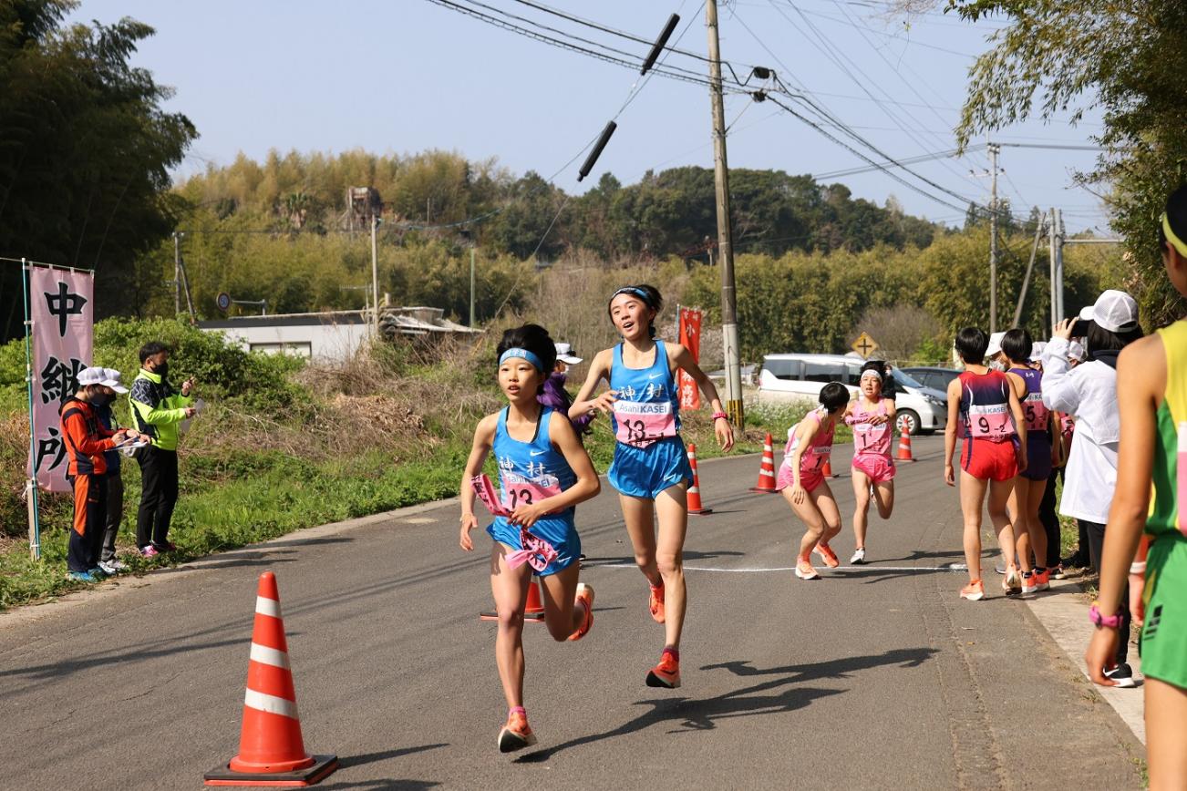 中継所で襷を繋ぐ女子選手たちの写真