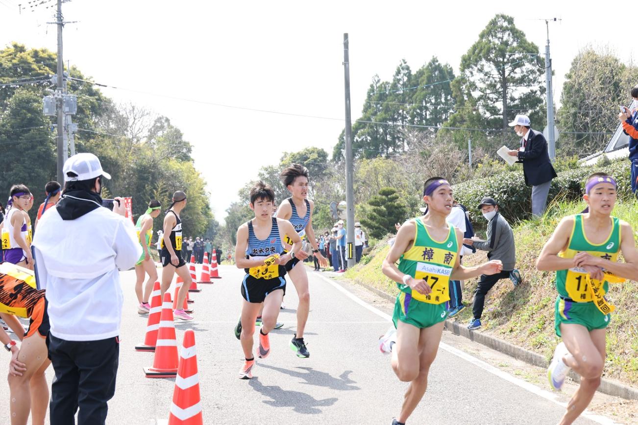 中継所で襷を繋ぐ男子選手たちの写真