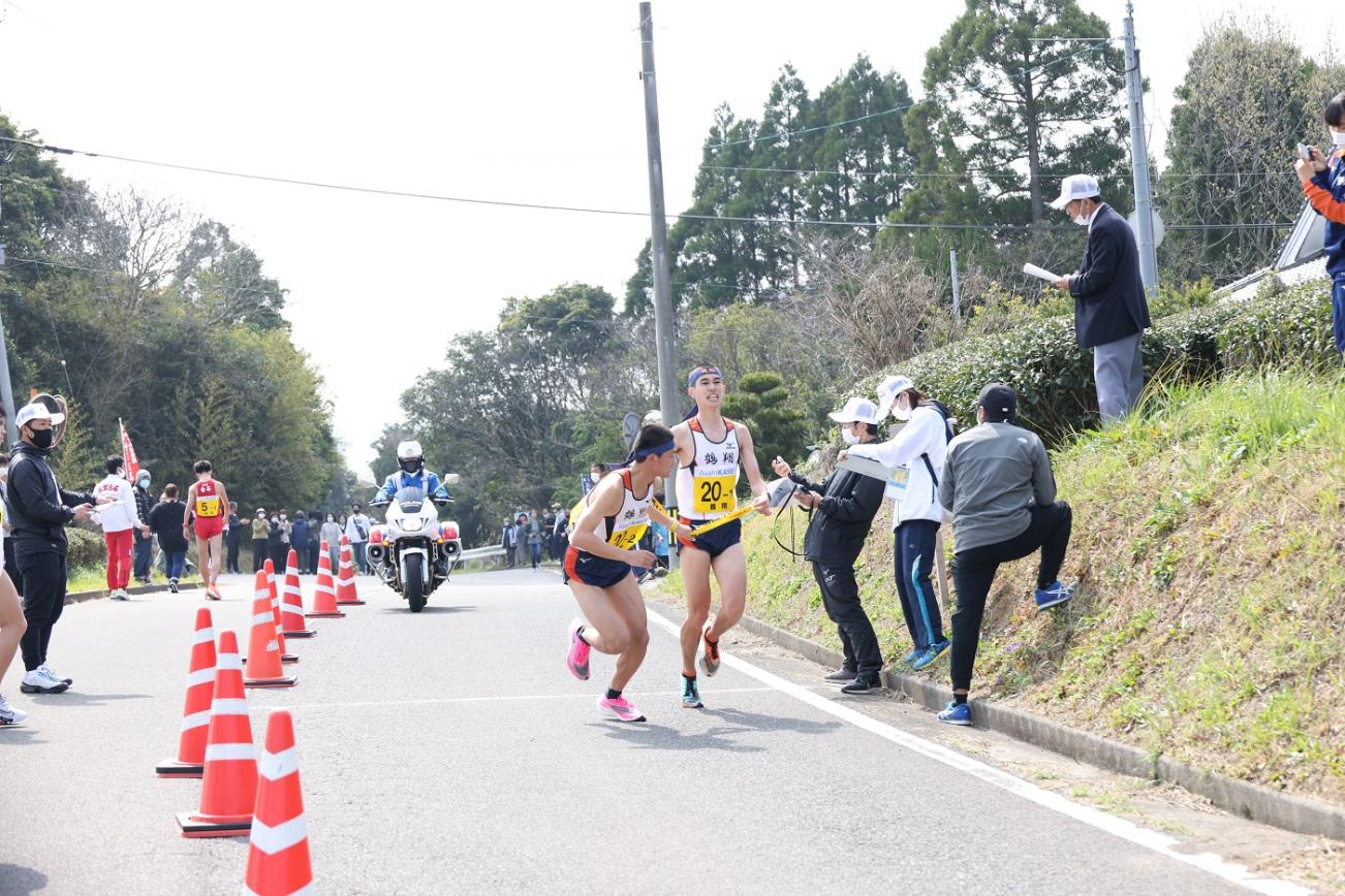 中継所で襷を繋ぐ男子選手たちの写真