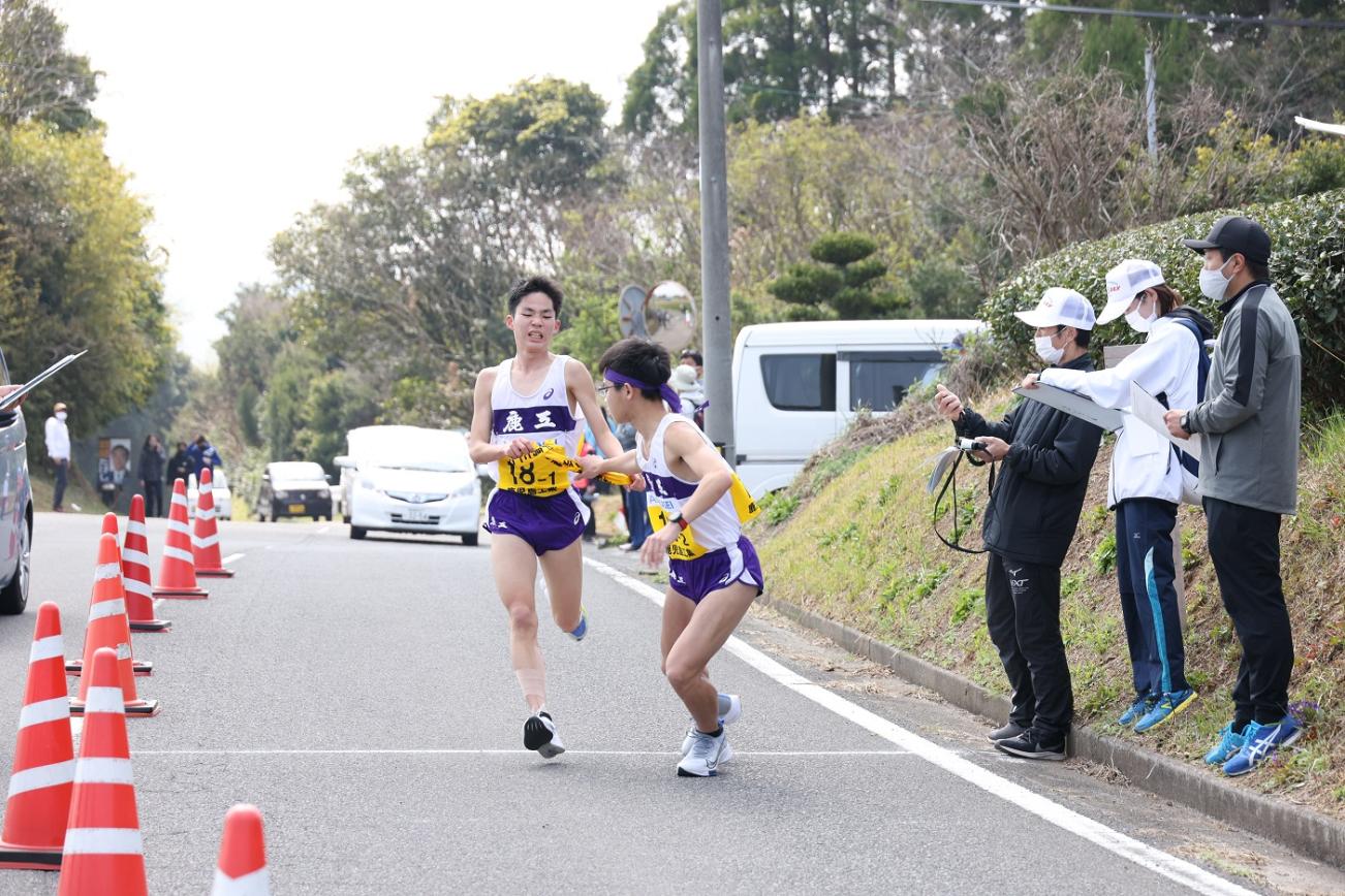 中継所で襷を繋ぐ男子選手たちの写真