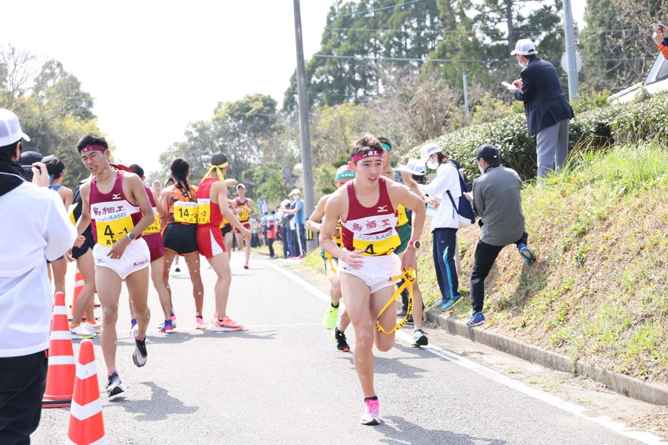 中継所で襷を繋ぐ男子選手たちの写真