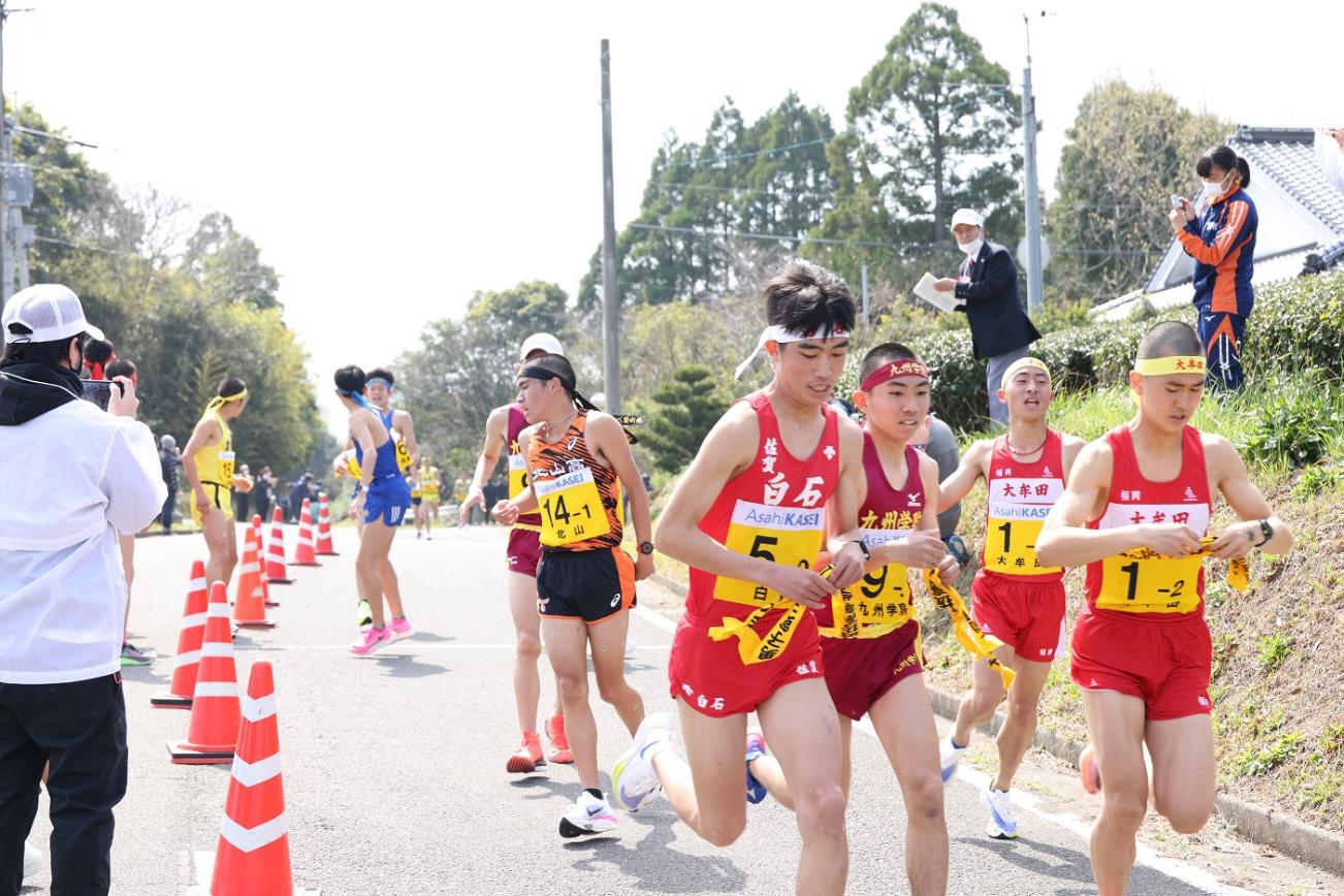 中継所で襷を繋ぐ男子選手たちの写真