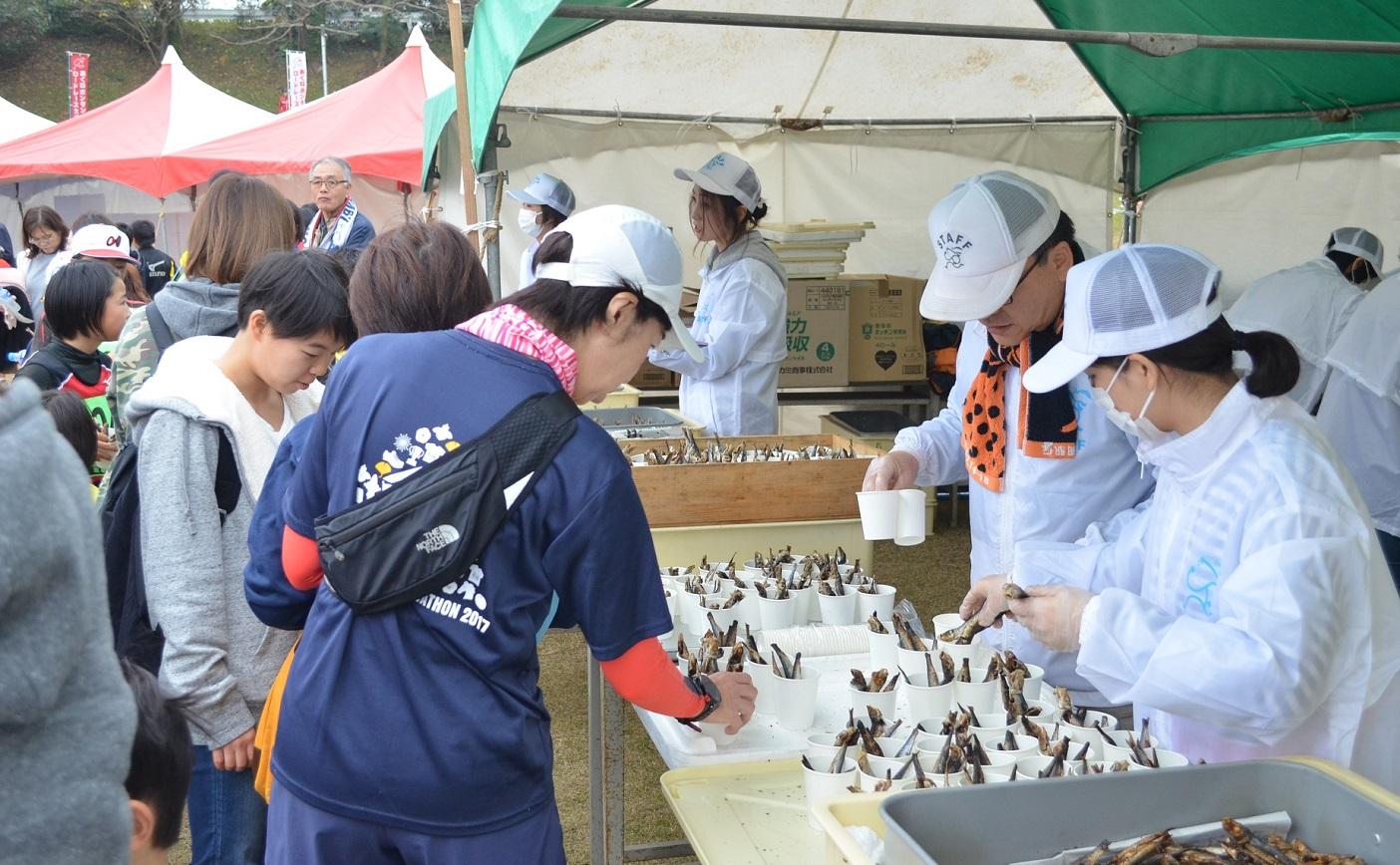 ゴール後のテントで、食べ物を選ぶ参加者たち