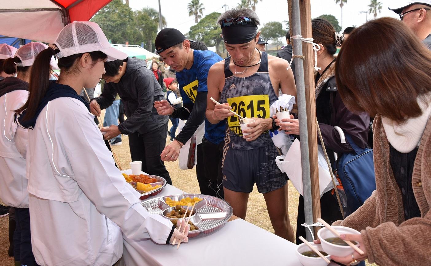 ゴール後のテントで、出された食材を食べる参加者たち