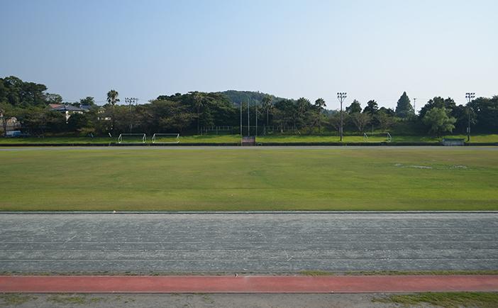 緑の天然芝が広がるフィールドのまわりを400メートルのトラックがある陸上競技場の写真