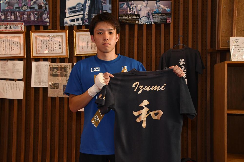 和泉氏のTシャツを持つ西田選手