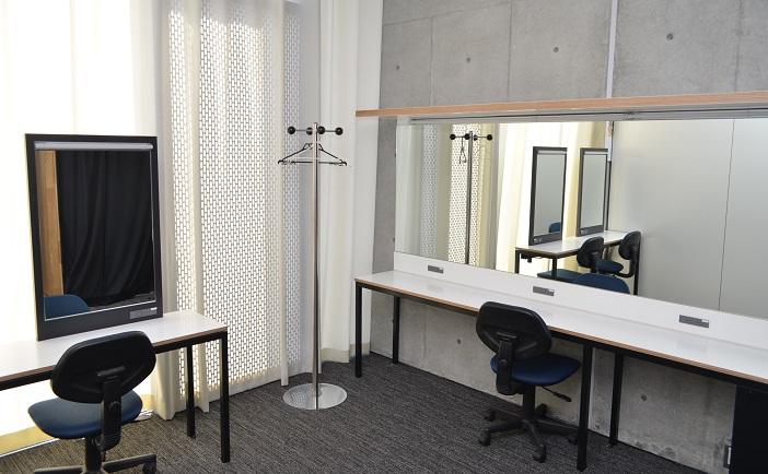 大きい鏡とカウンターとイスのある阿久根市民交流センター（風テラスあくね）楽屋2の写真