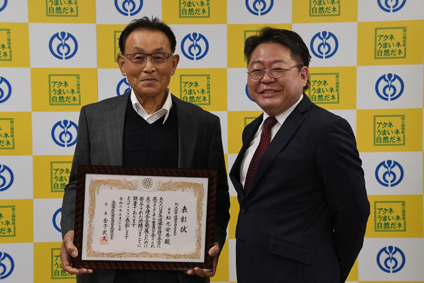 市選挙管理委員の松元安秀さんと西平市長の写真
