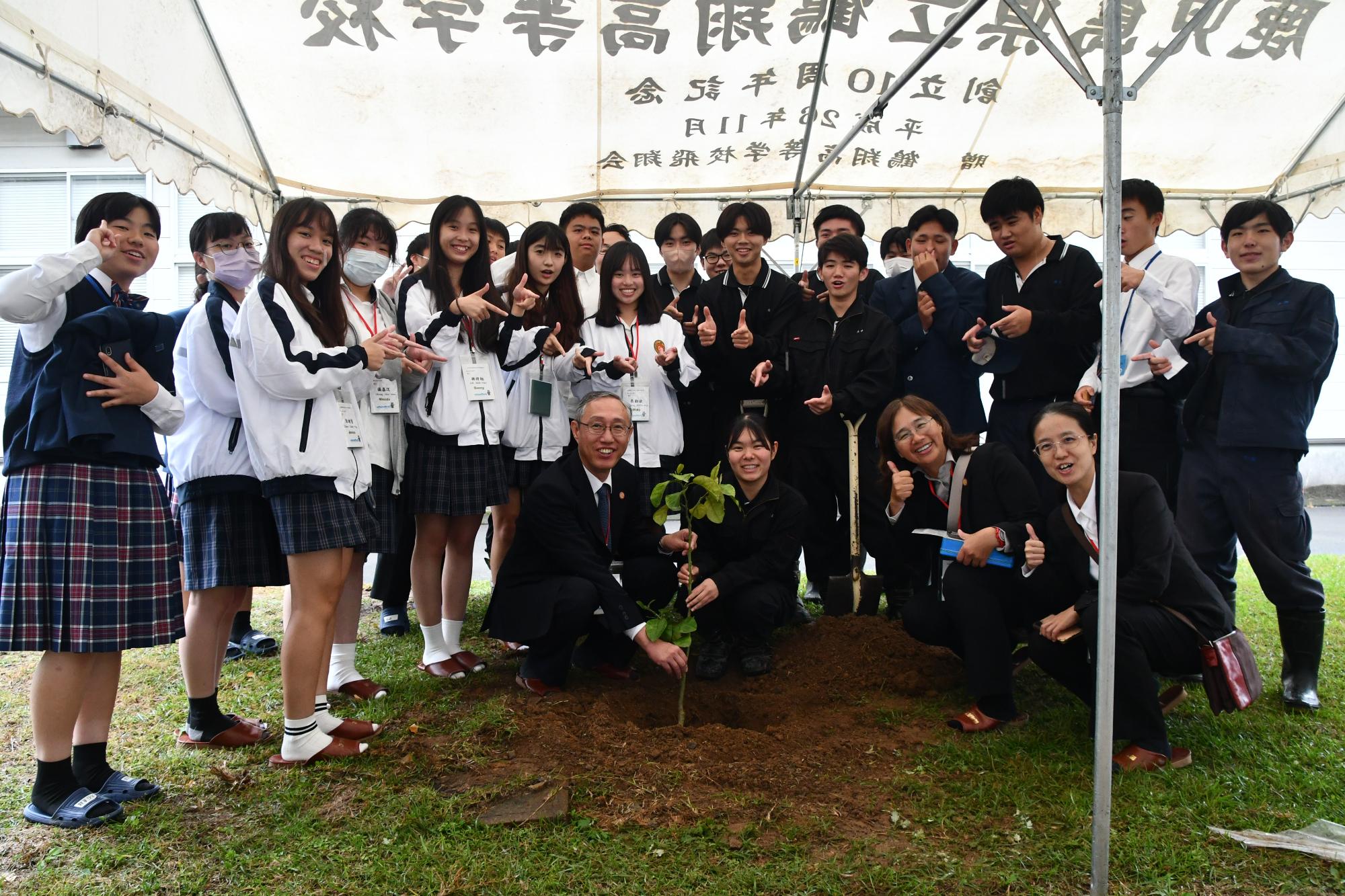 記念樹を植える善化高校と鶴翔高校の生徒