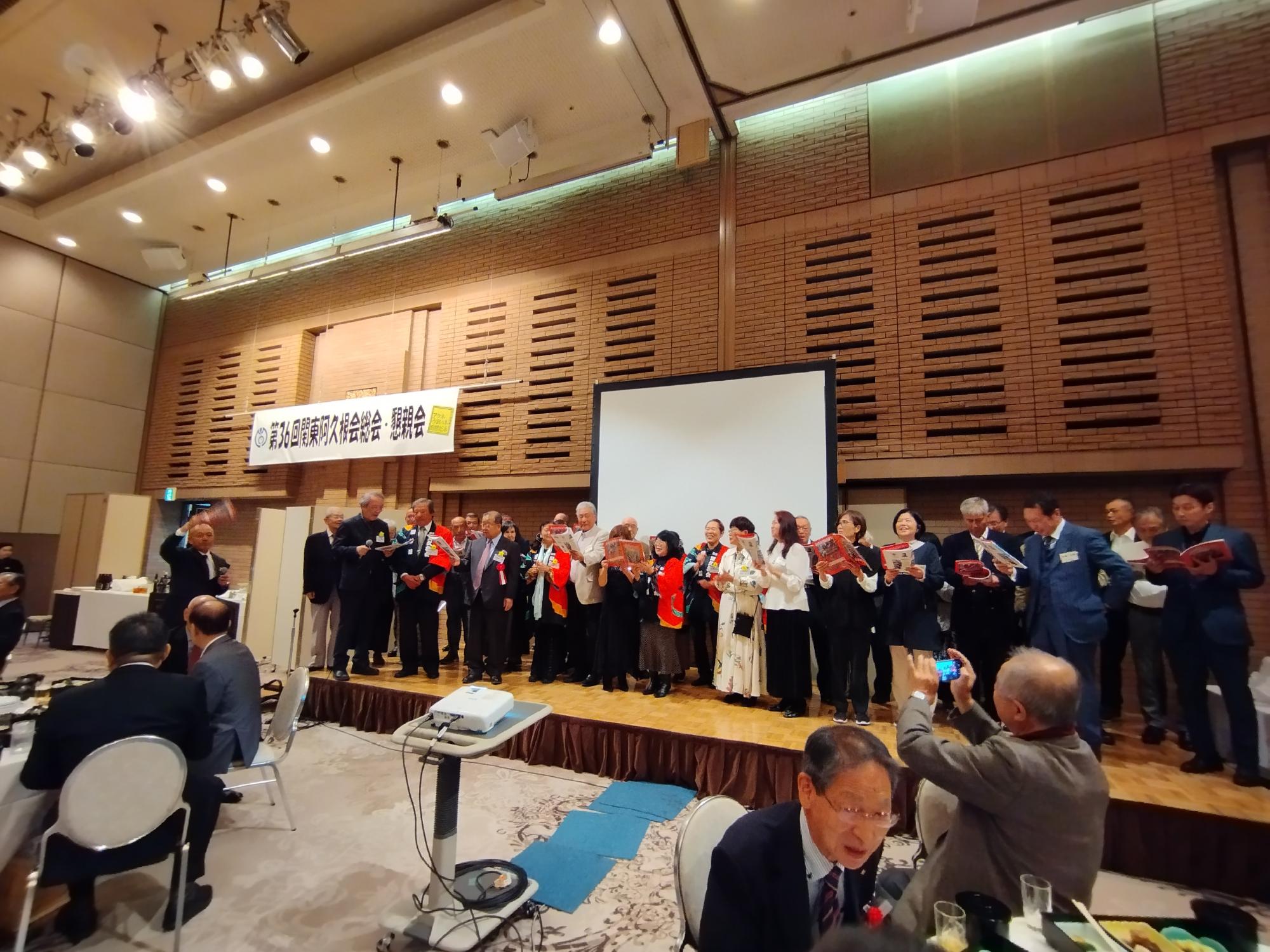 関東阿久根会総会・懇親会において小学校の校歌を合唱する参加者
