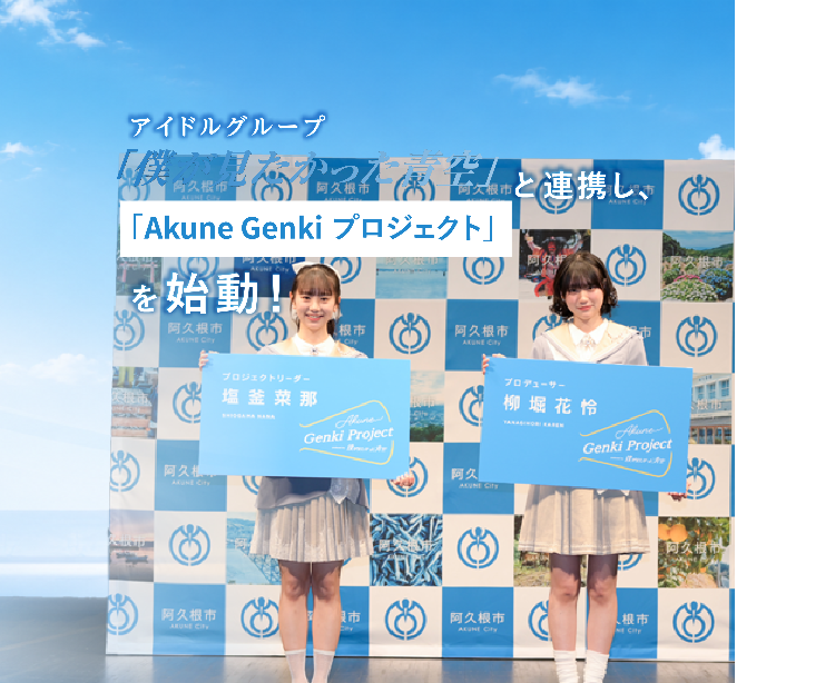 「僕が見たかった青空」の塩釜さんと柳堀さんが特大名刺を持って記念撮影する写真