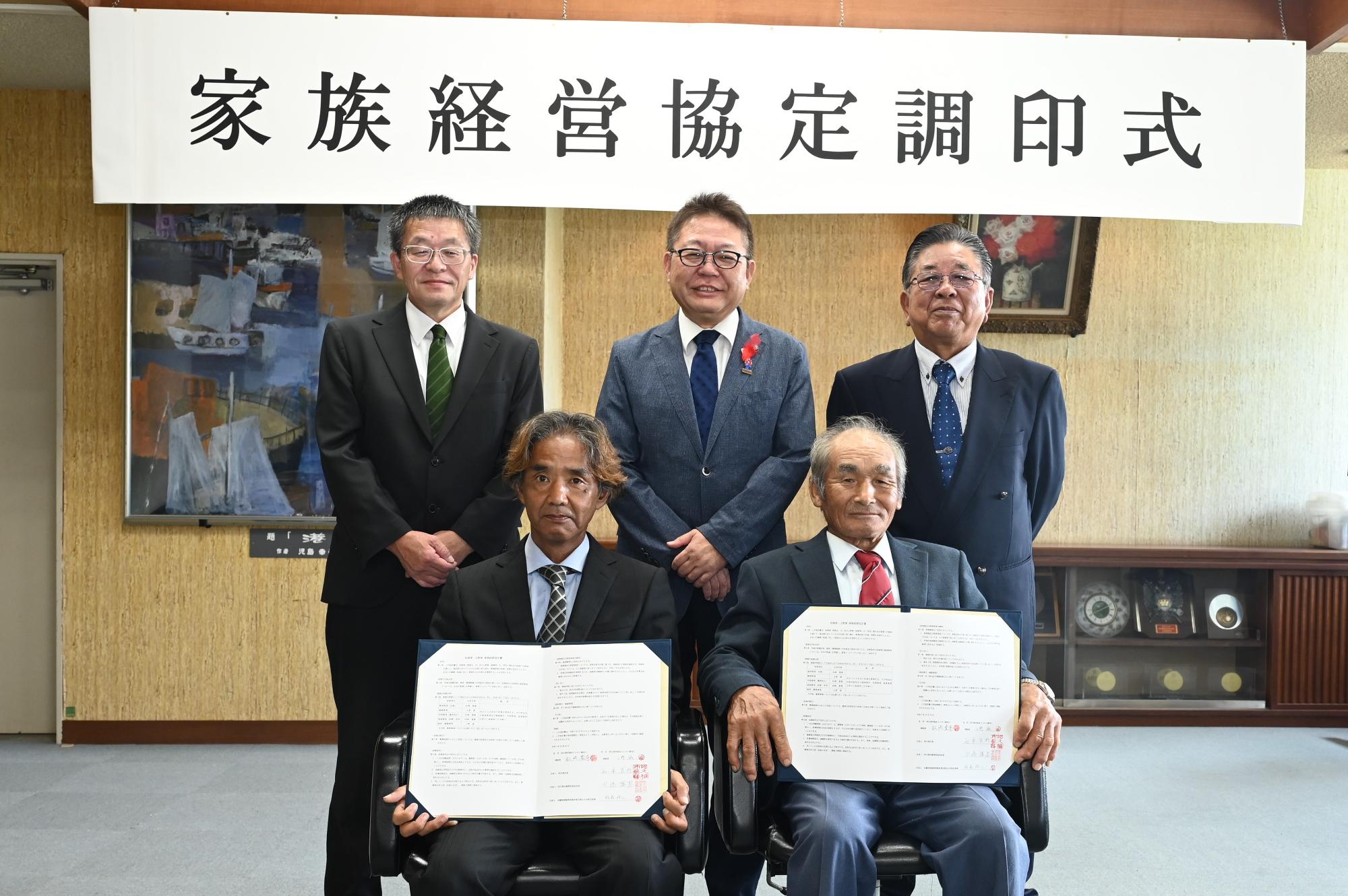 家族経営協定で記念撮影をする西平市長（写真上段真ん中）と松崎家、上野家の写真