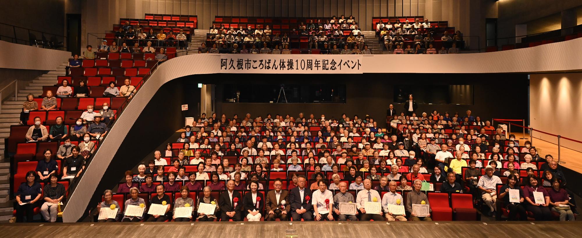 ころばん体操10周年記念イベントで記念撮影をする参加者らの写真