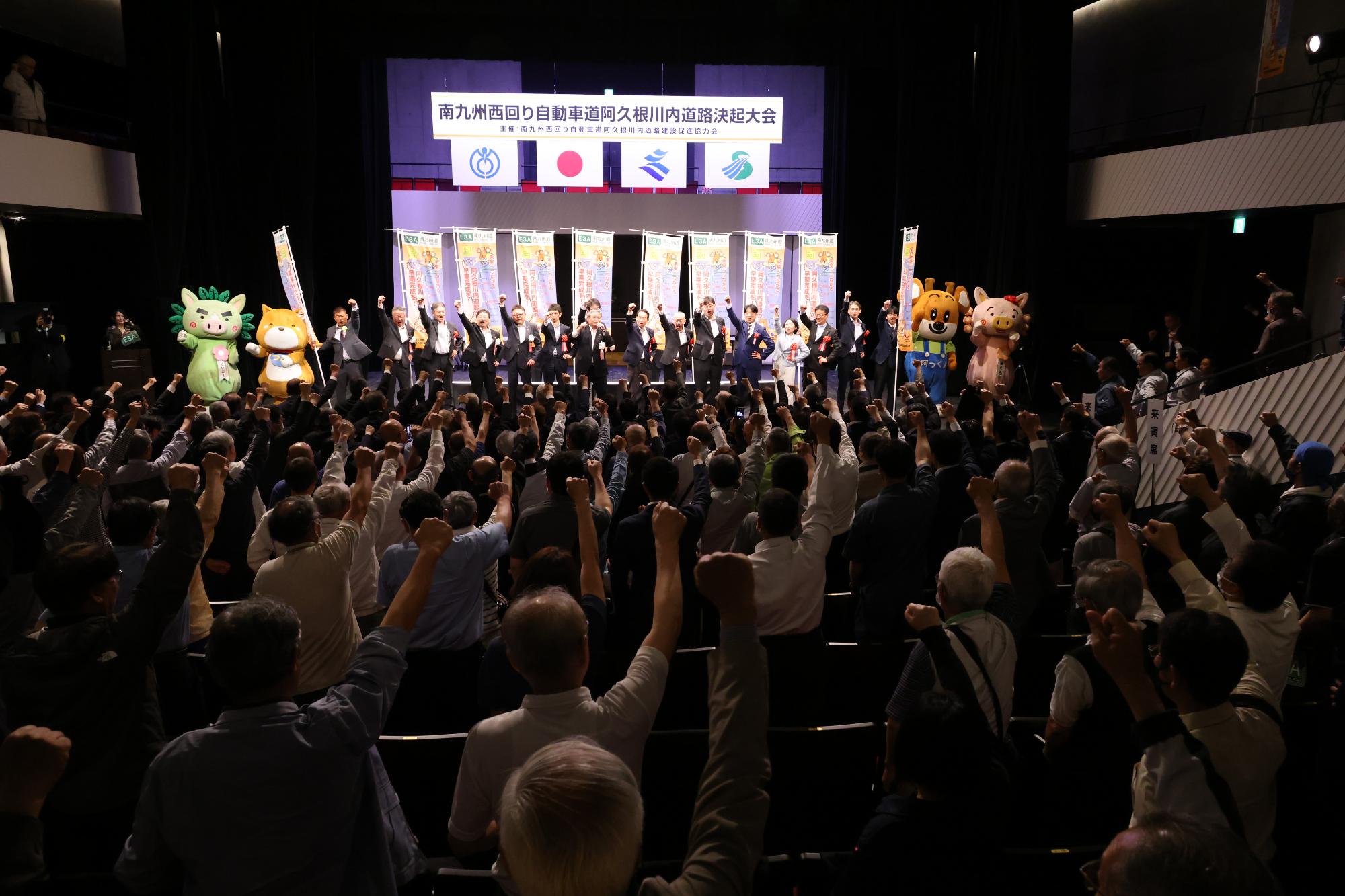 南九州西回り自動車道阿久根川内道路決起大会で会場にいる全員でがんばろう三唱をする様子