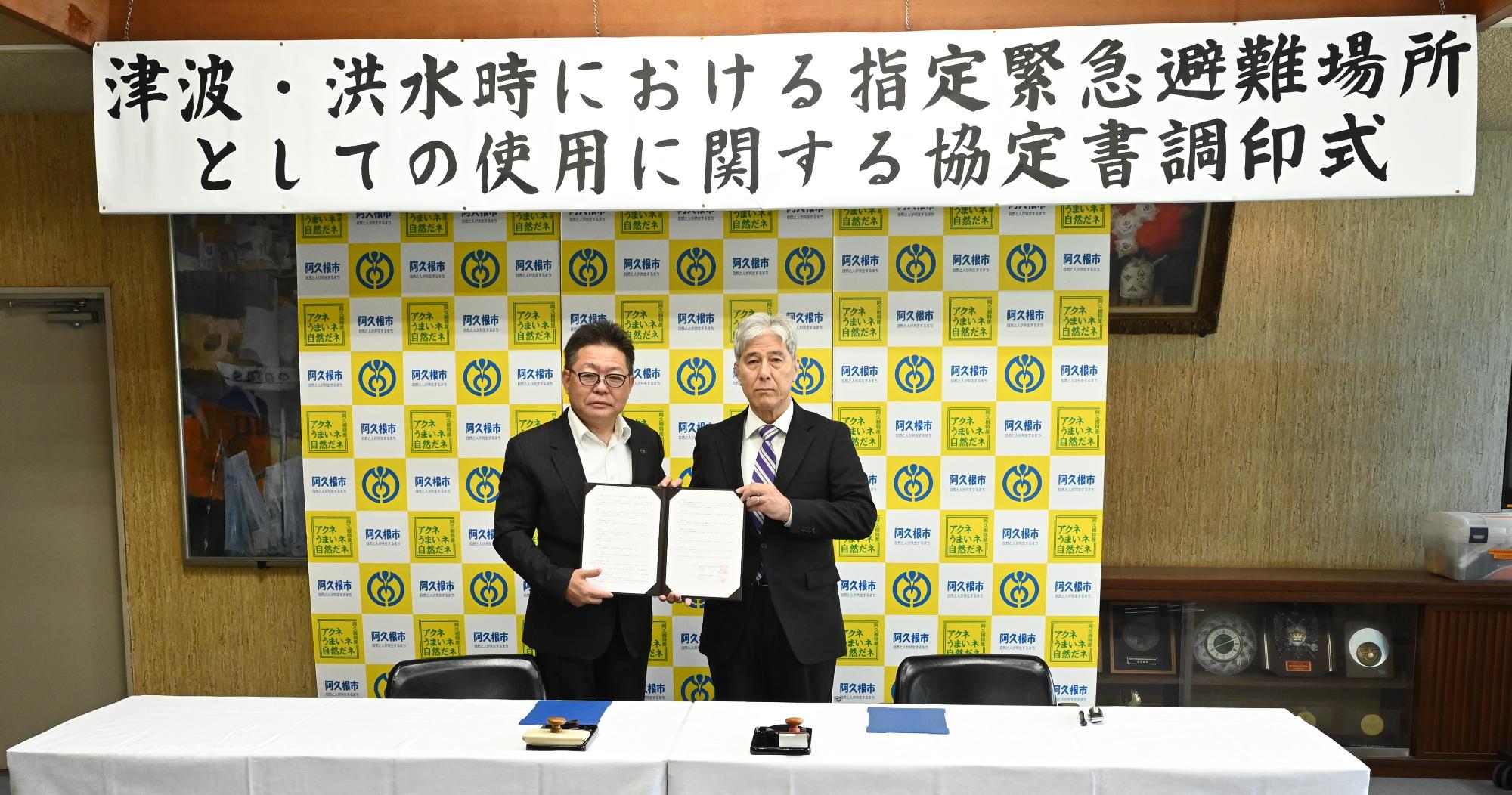 調印式で記念撮影する西平市長と田原秀一社長