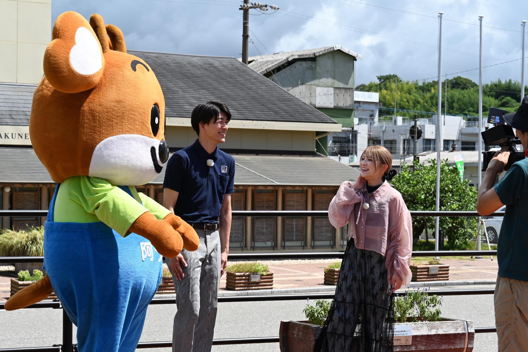 スゴマチのロケをする（左から）阿っくん、市商工観光課職員と矢口真理さんの写真